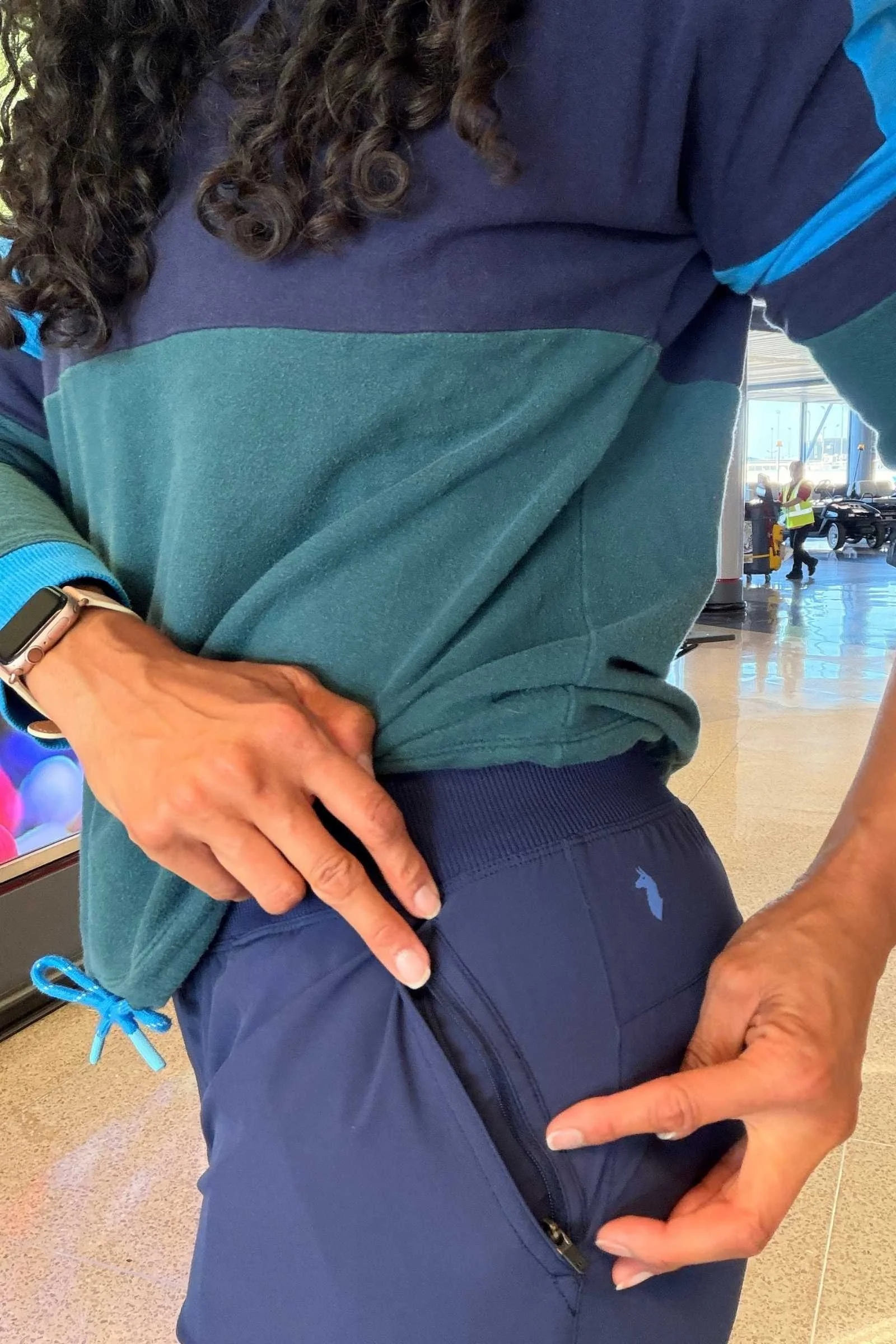 Close-up of a hidden zip pocket on the inside waistband of the Cotopaxi Cambio travel pants
