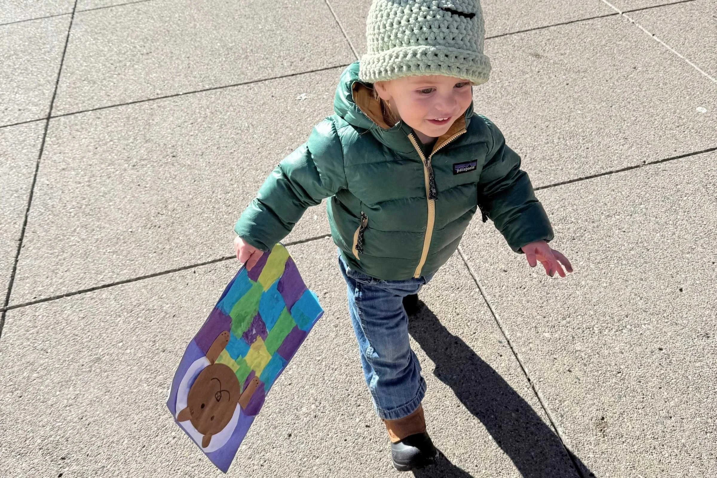 Child wearing boots on sidewalk to school