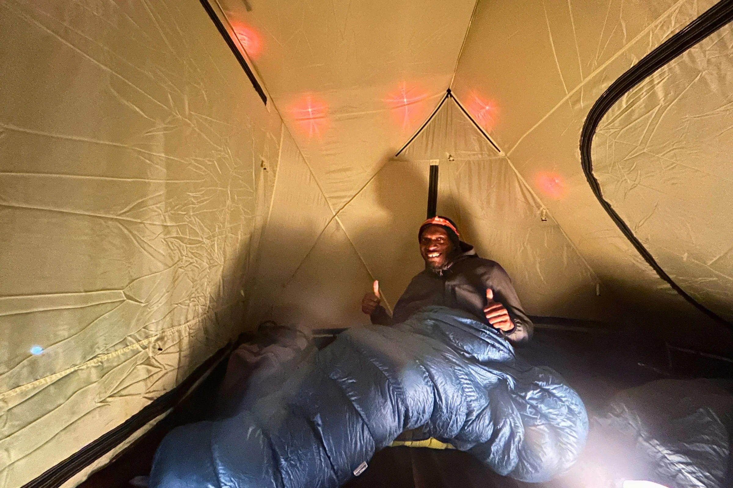 Camping in the Snow Peak Alpha Breeze with the BioLite Solar String Lights (in red) set outside.