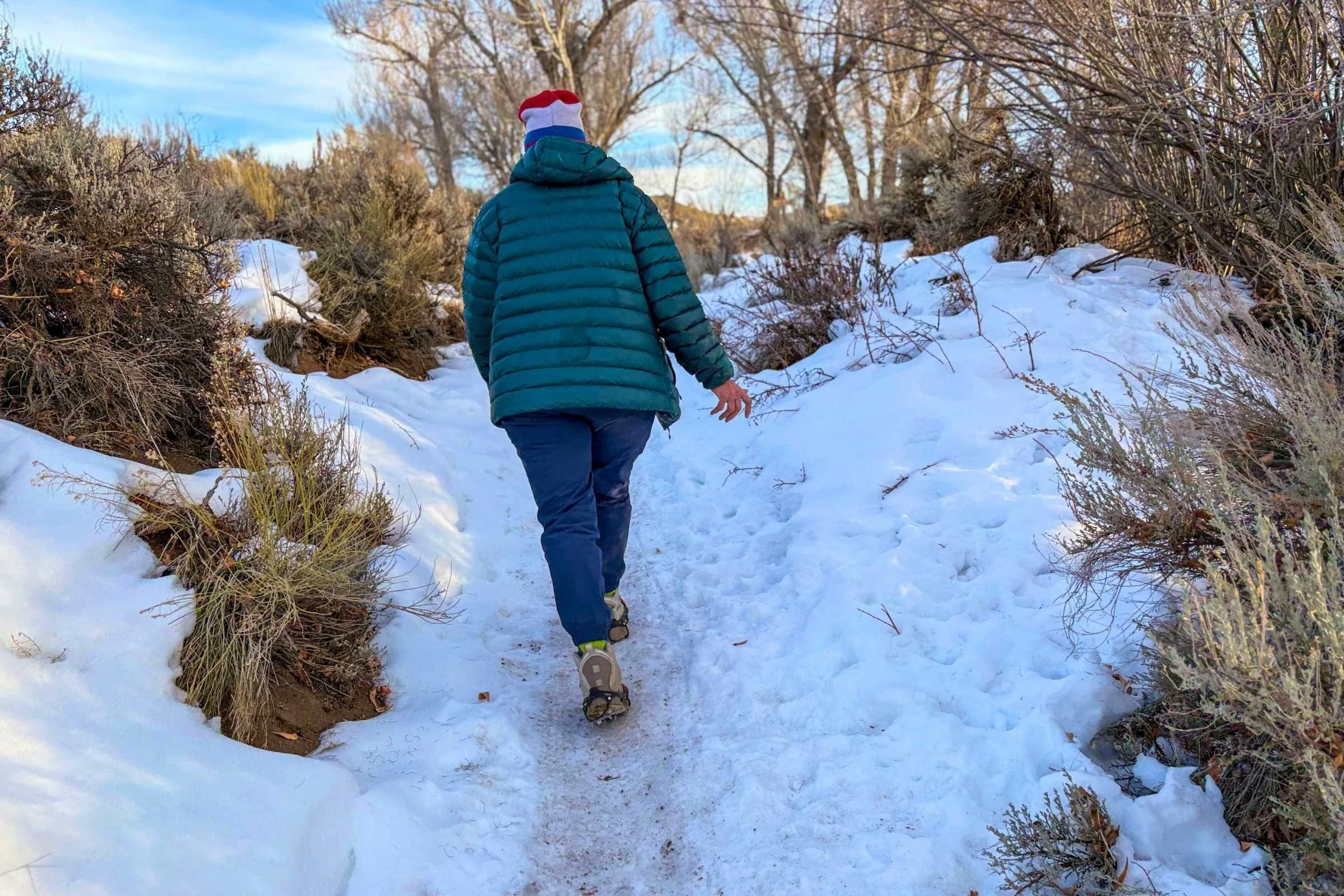 hiker walking on hardpacked snow in the kahtoola microspikes ghosts