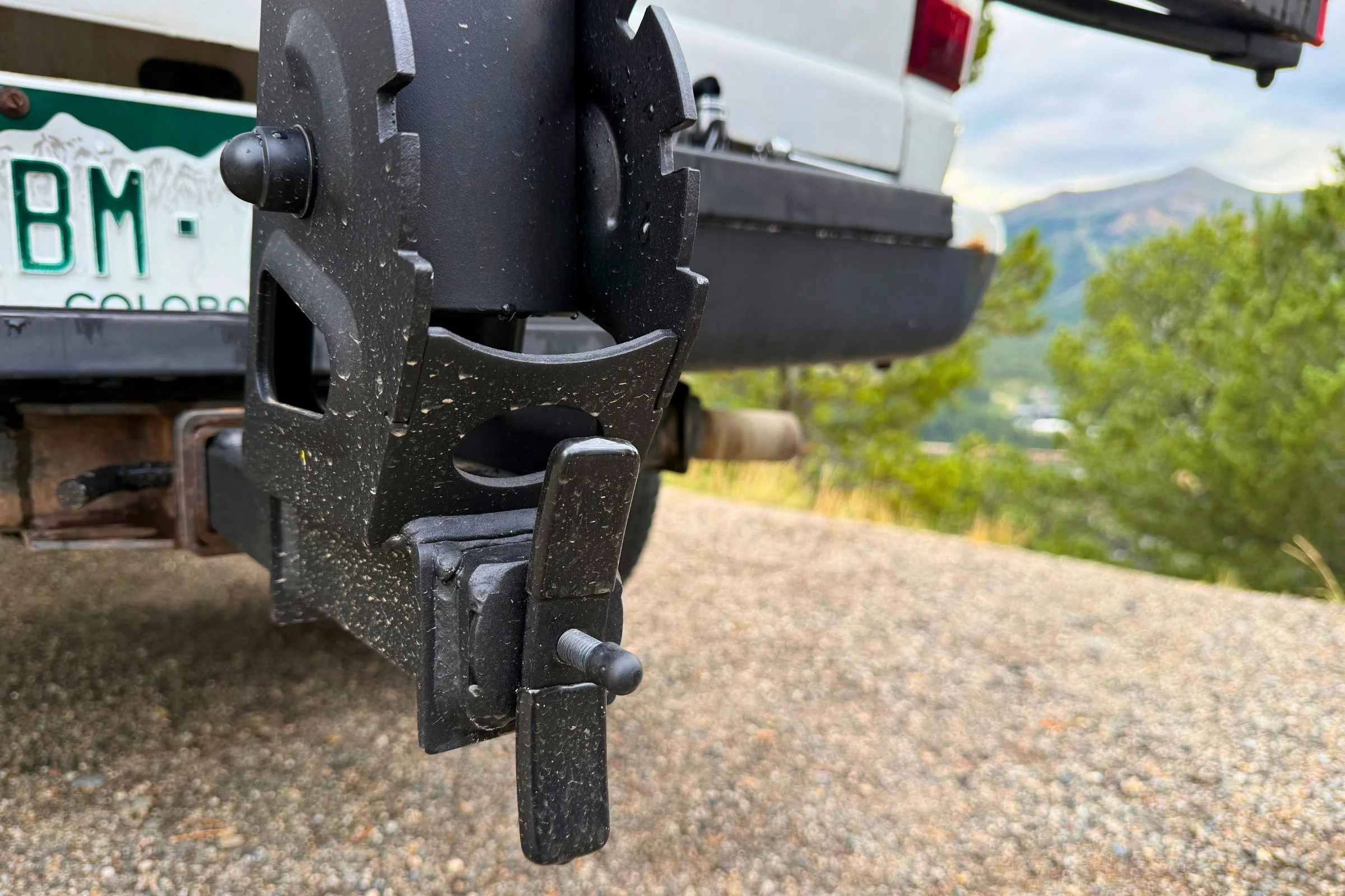 Close-up of the hitch-mount connection on a truck demonstrating the anti-wobble feature of a Hollywood Racks CrossTrack Hitch Bike Rack.