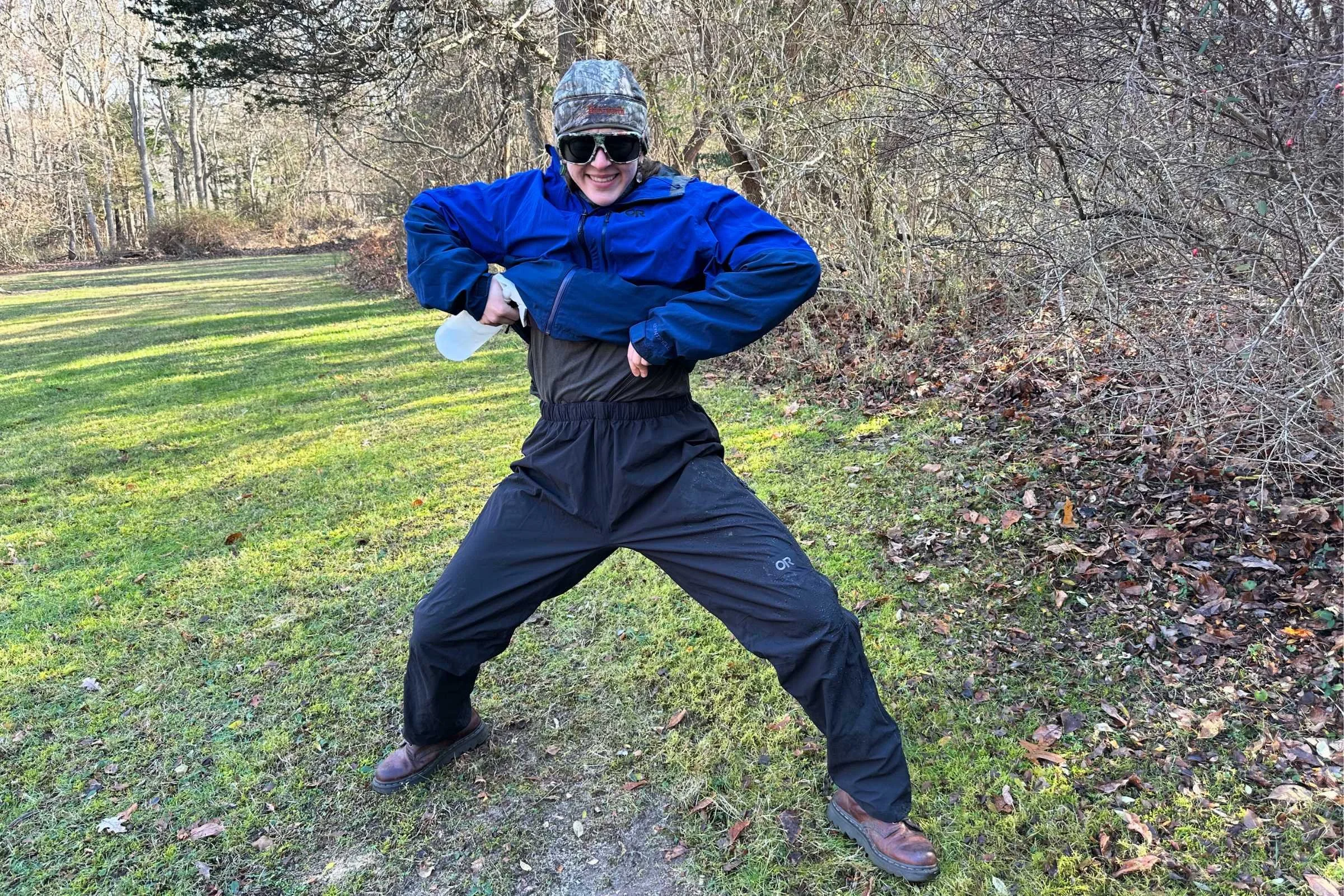 Elliot standing in the Foray rain pants in wide stance while holding a spray bottle.