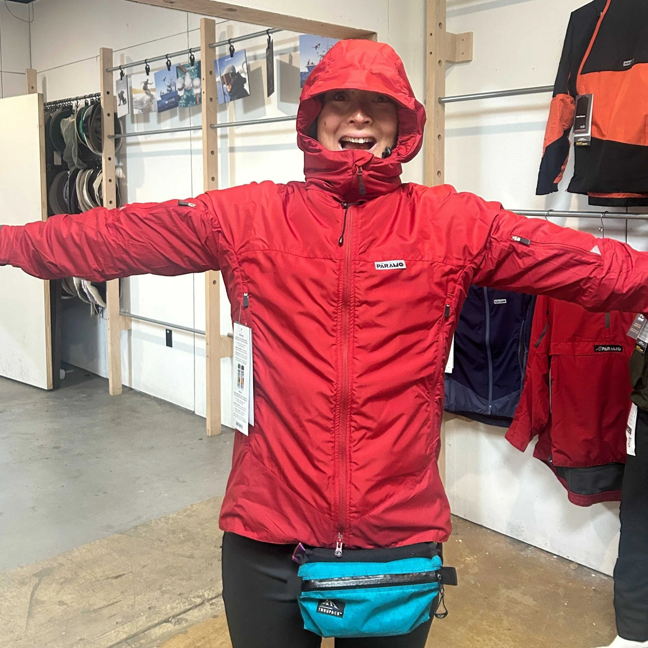 Liz Thomas trying on the new PFAS-free waterproofing in the Paramo rain jackets at OMA.
