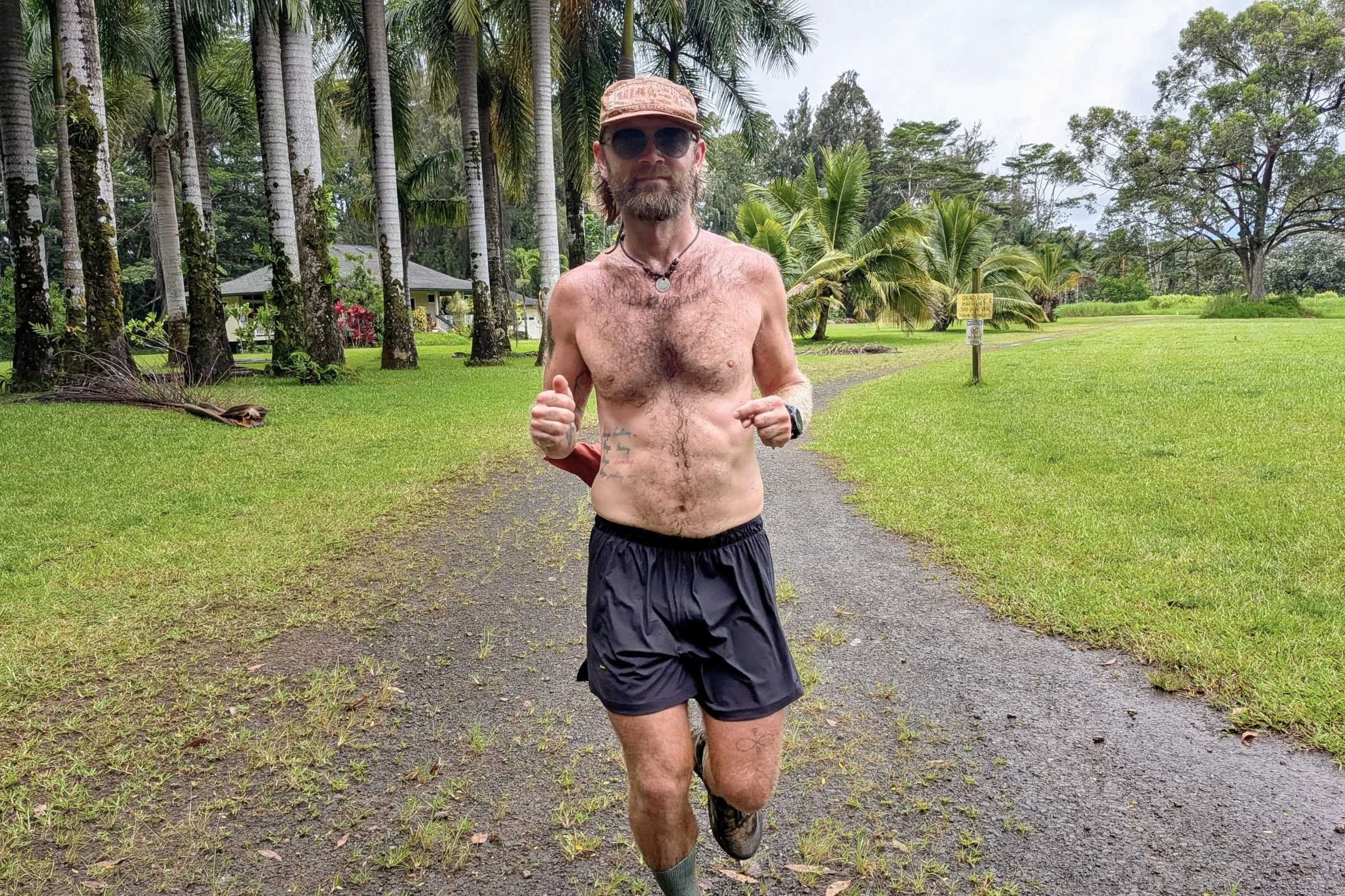 The author wearing the Tracksmith Twilight running shorts in Hawaii with palm trees in the background
