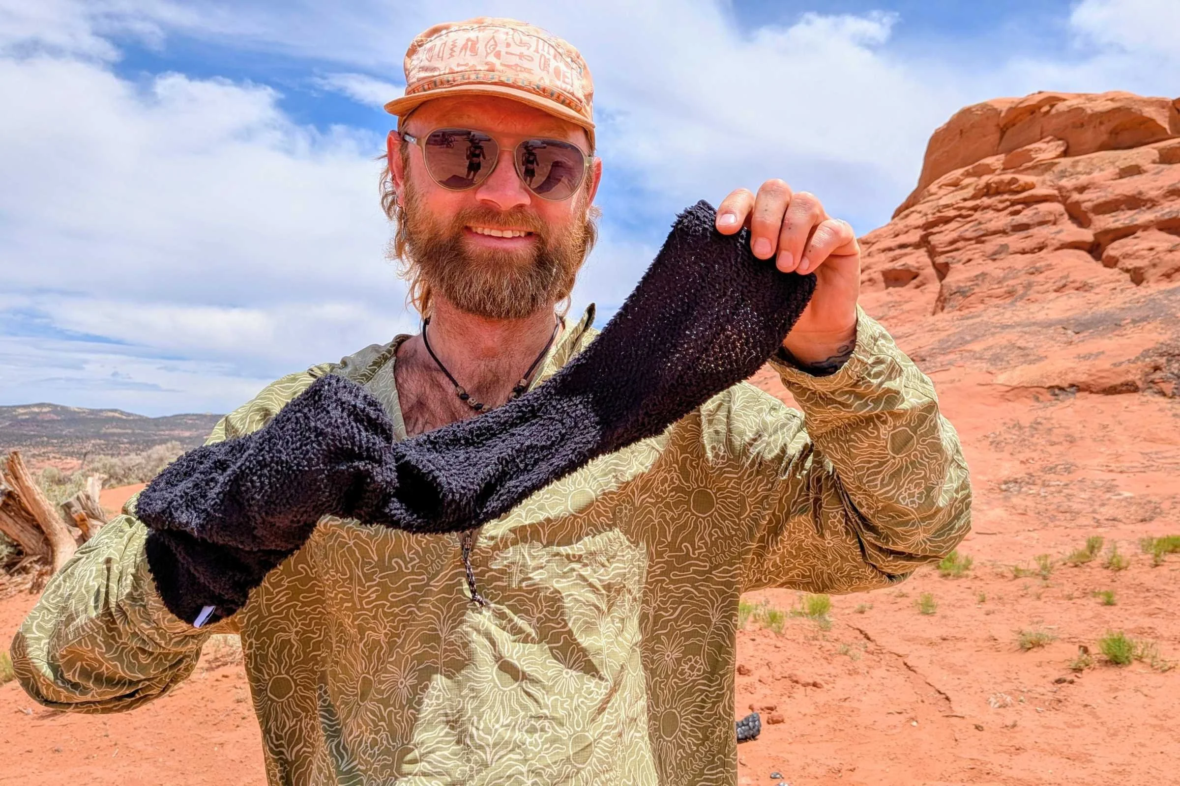author Sam Schild holds up a FarPointe Outdoor Gear Alpha Direct Sock on a sunny day