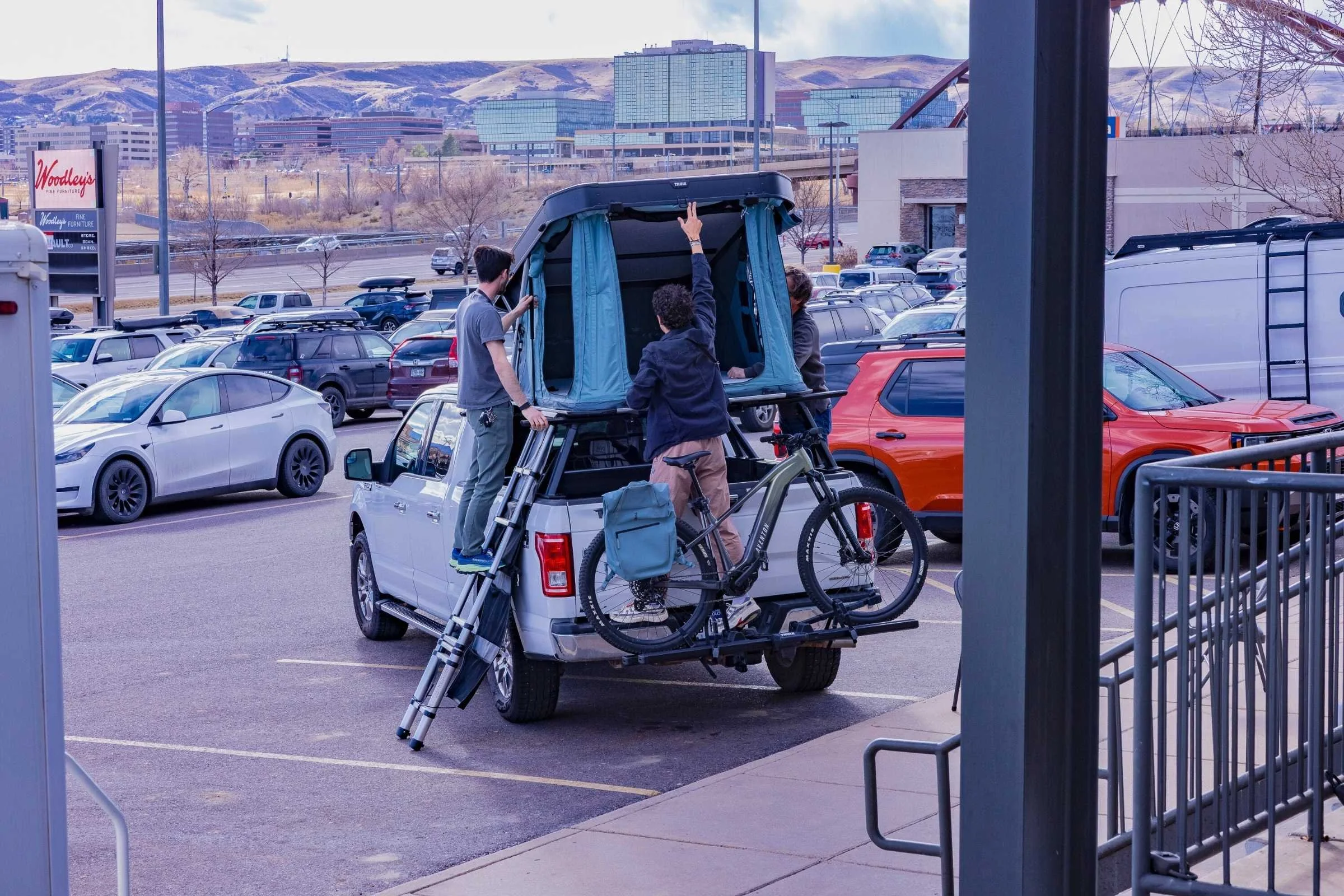 Kai checking out a THULE hardshell rooftop tent mounted on a pickup truck at the Outdoor Market Alliance show.