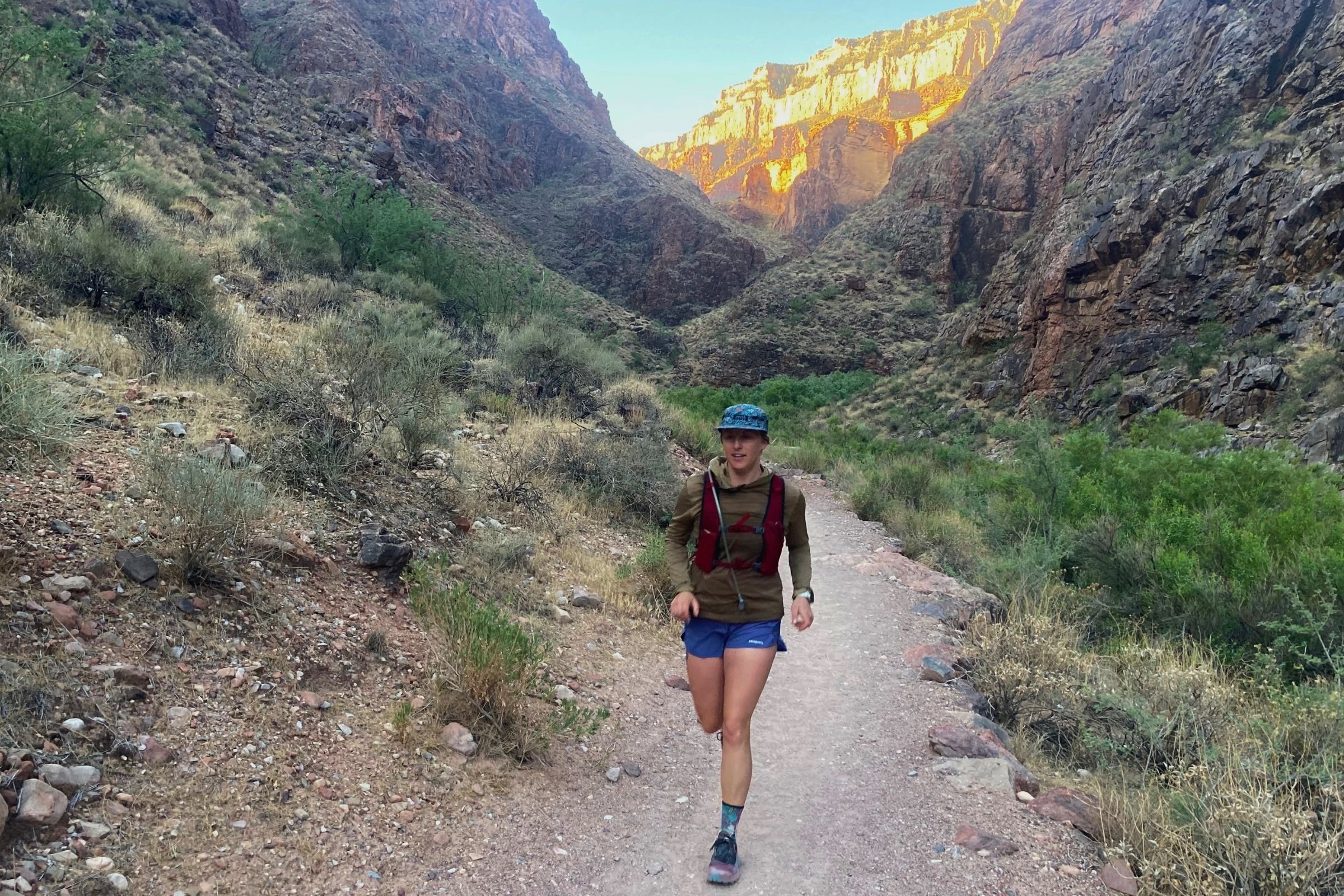 Woman in Patagonia Strider Pro shorts hiking through a canyon.