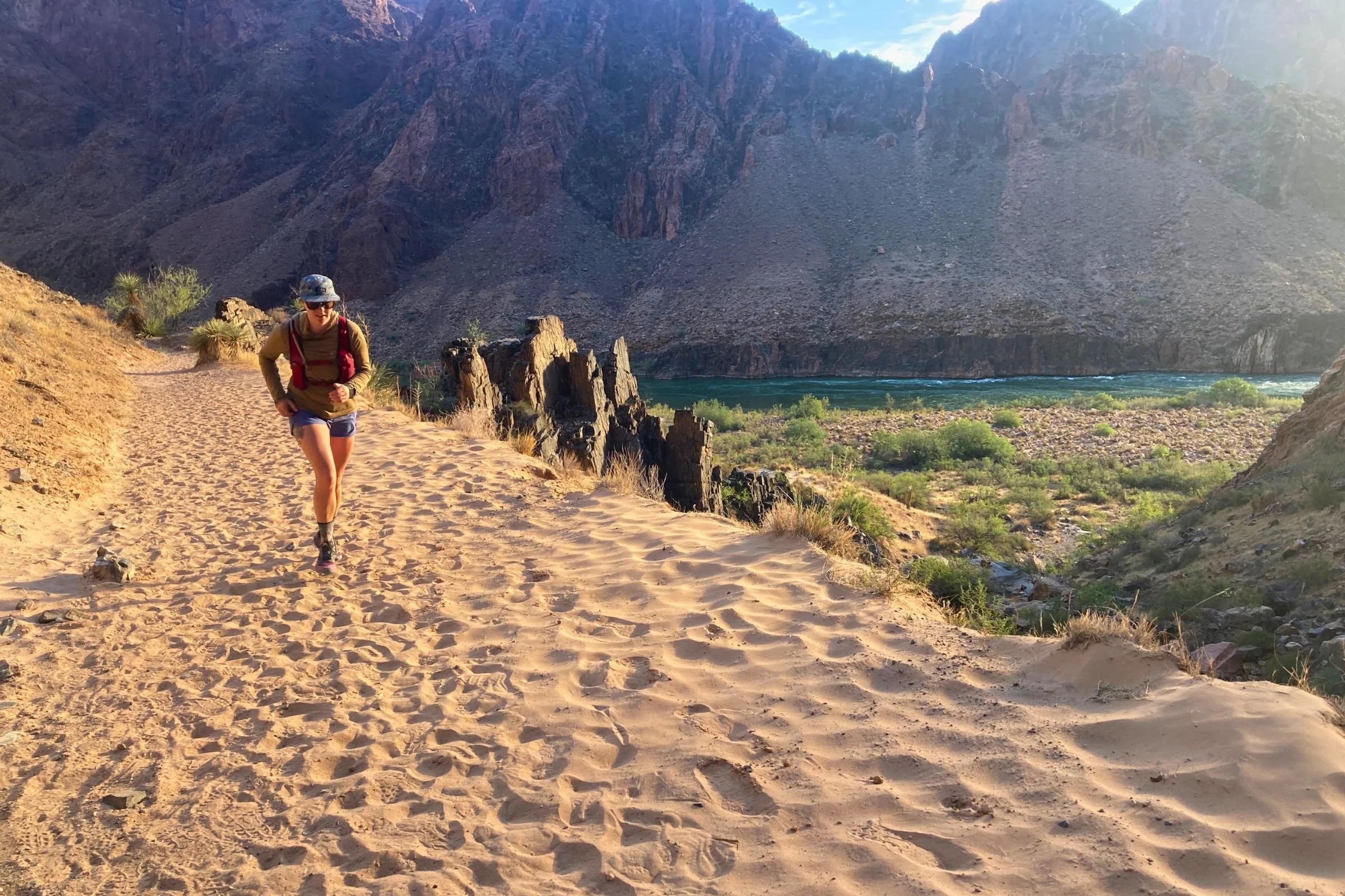 Woman in Patagonia Strider Pro shorts running on a trail in the desert.