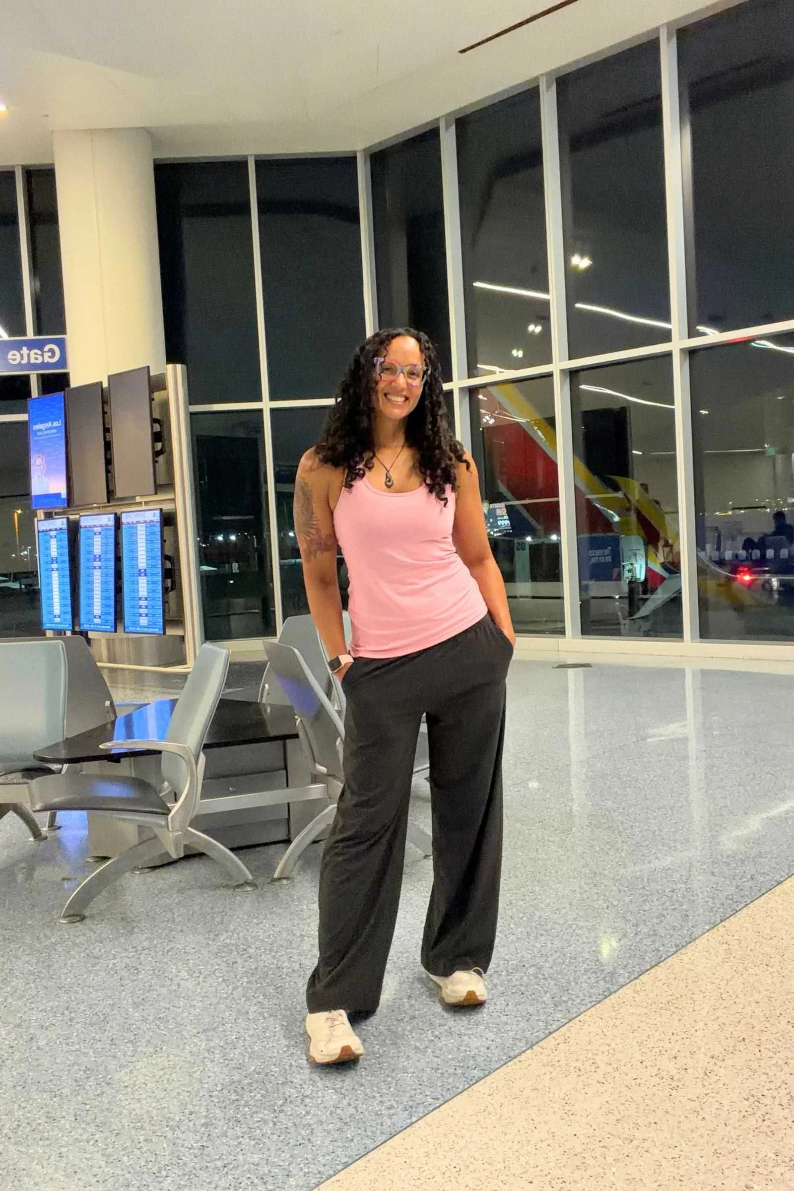 Woman wearing Vuori Villa Wide-Leg Long travel pants in dark grey color in an airport