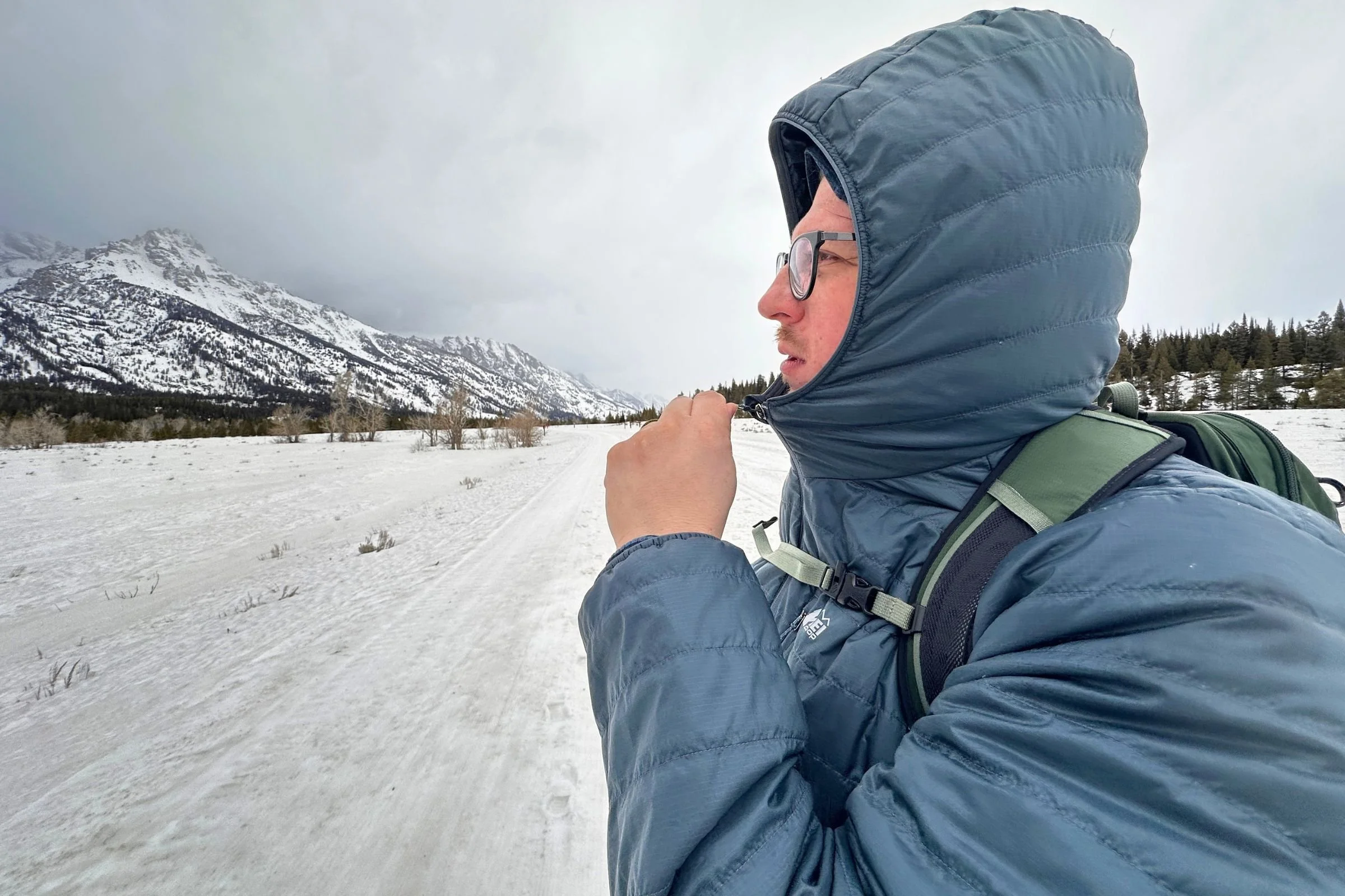 Tester wearing the REI Microtrek Insulated Hoodie on a snowy day