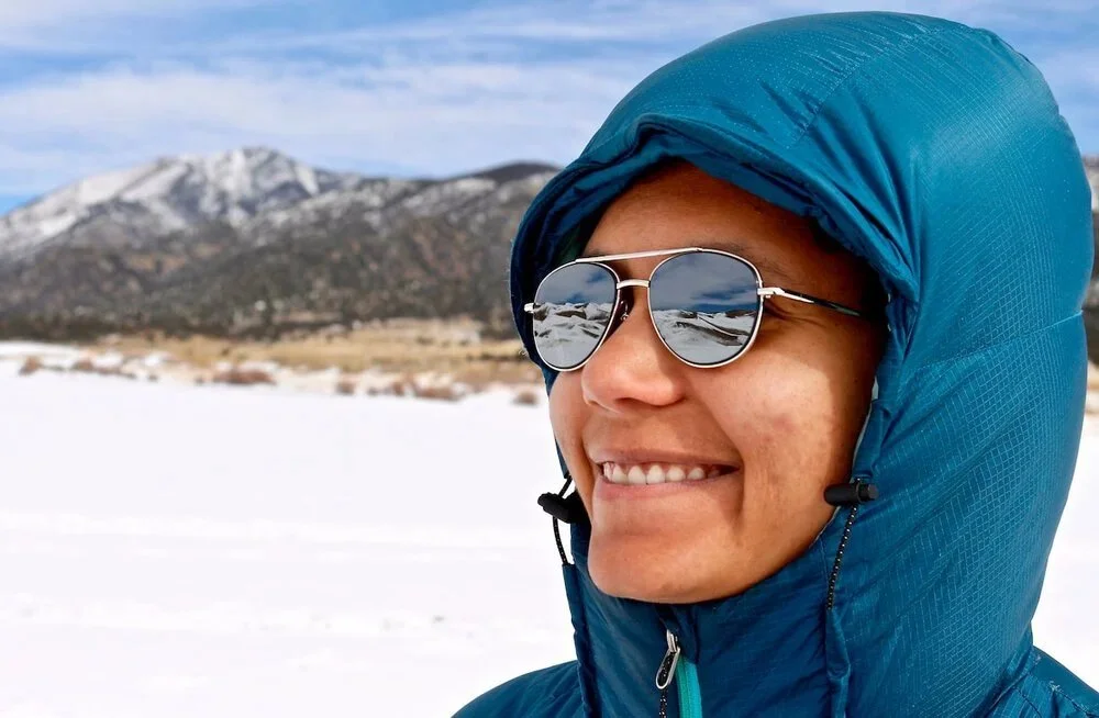 Person wearing a blue down jacket in snowy mountains