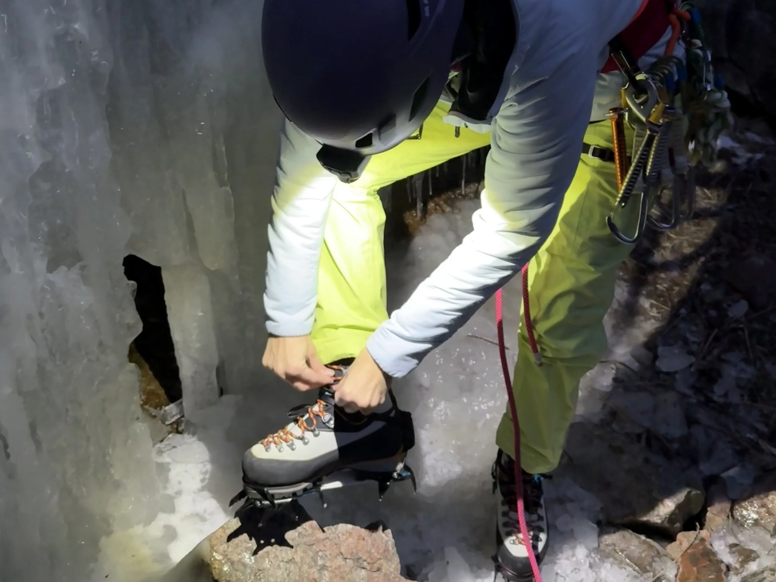 the author uses the coast headlamp to secure ice climbing crampons