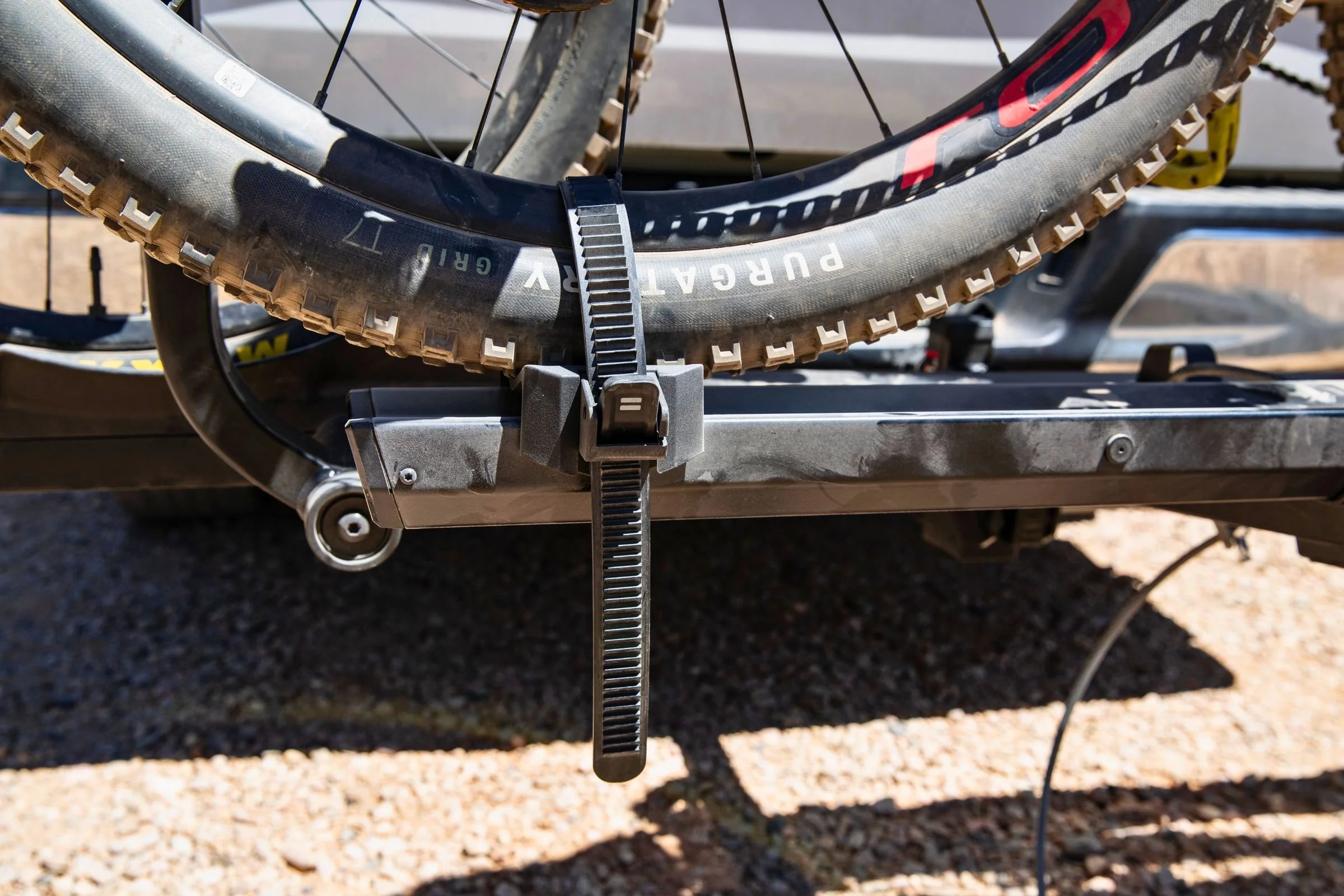 Close-up of the wheel clamp on the Yakima StepUp Swing 2” Hitch Bike Rack securing a bicycle.