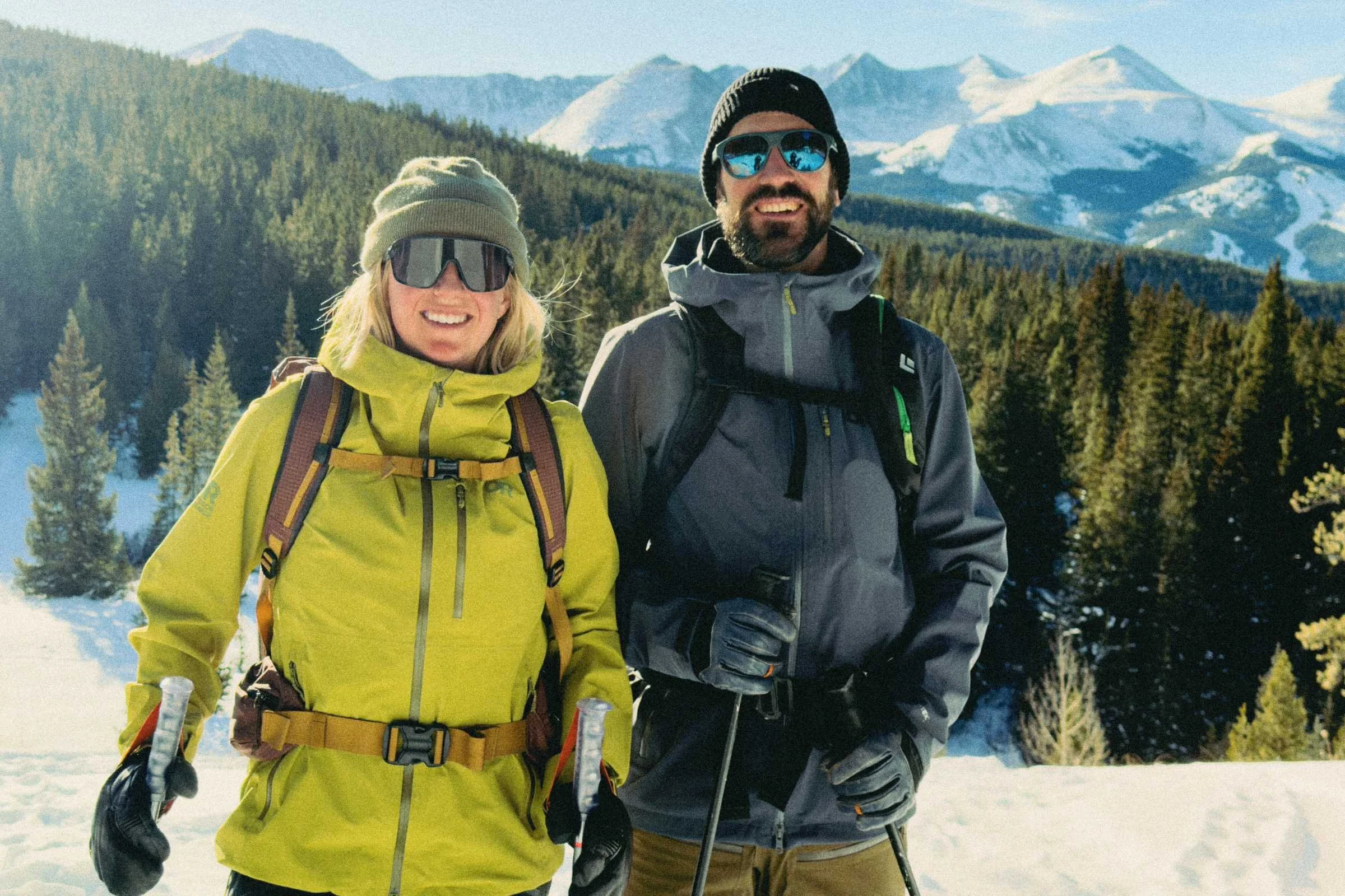 a woman (left) in a green OR Cloudchaser ski kit  and man (right) in a gray OR Cloudchaser ski kit.