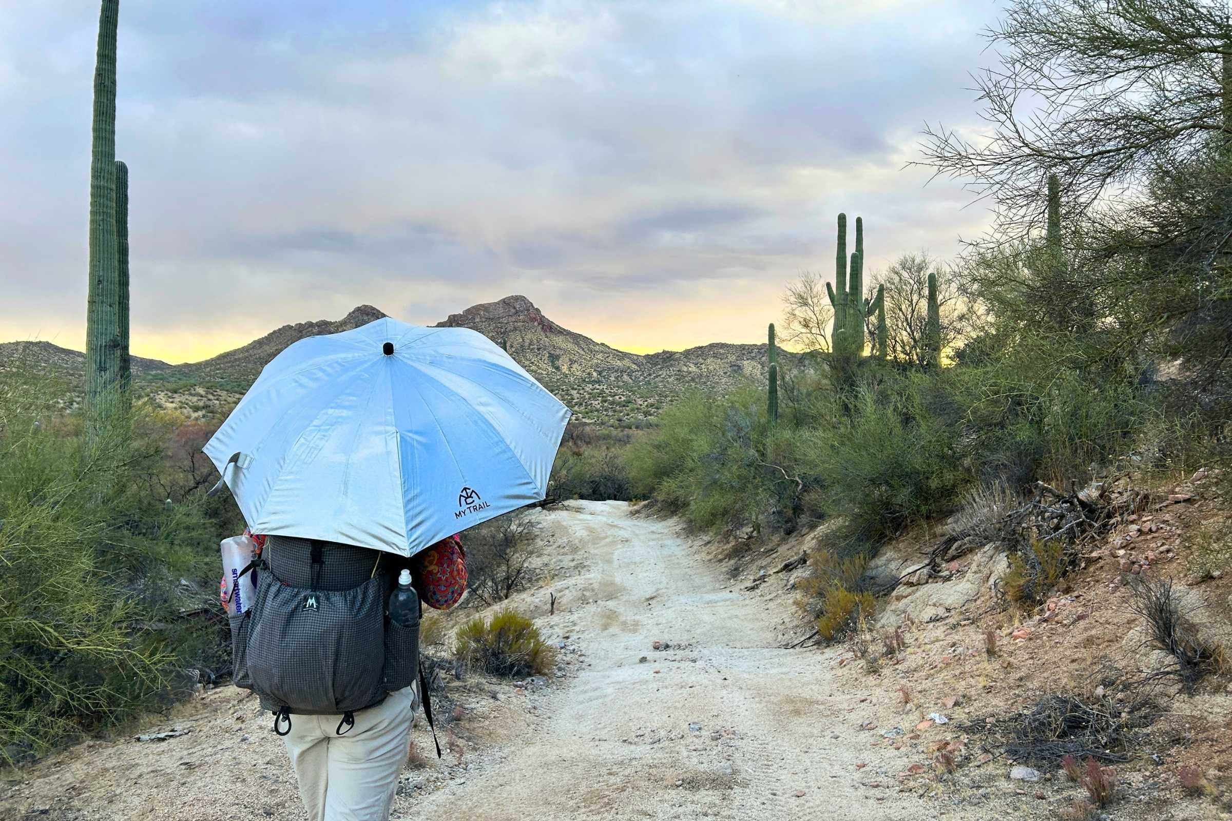 Hiker testing a silver hiking umbrella
