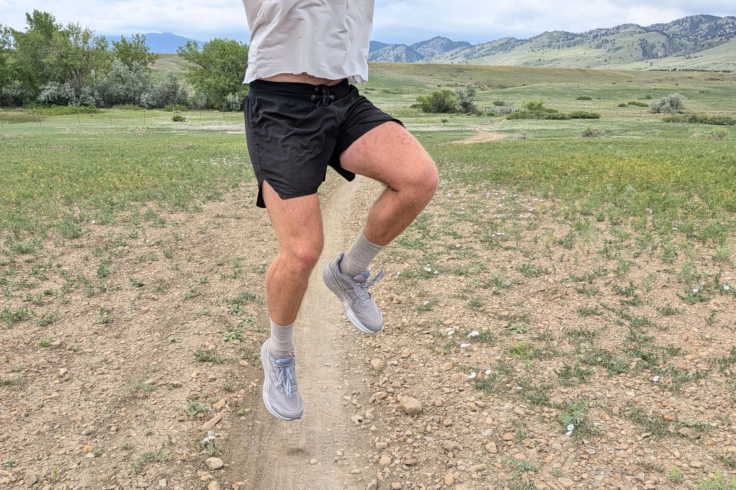 Man jumping on a dirt road while wearing Terignota Sendero Shorts.