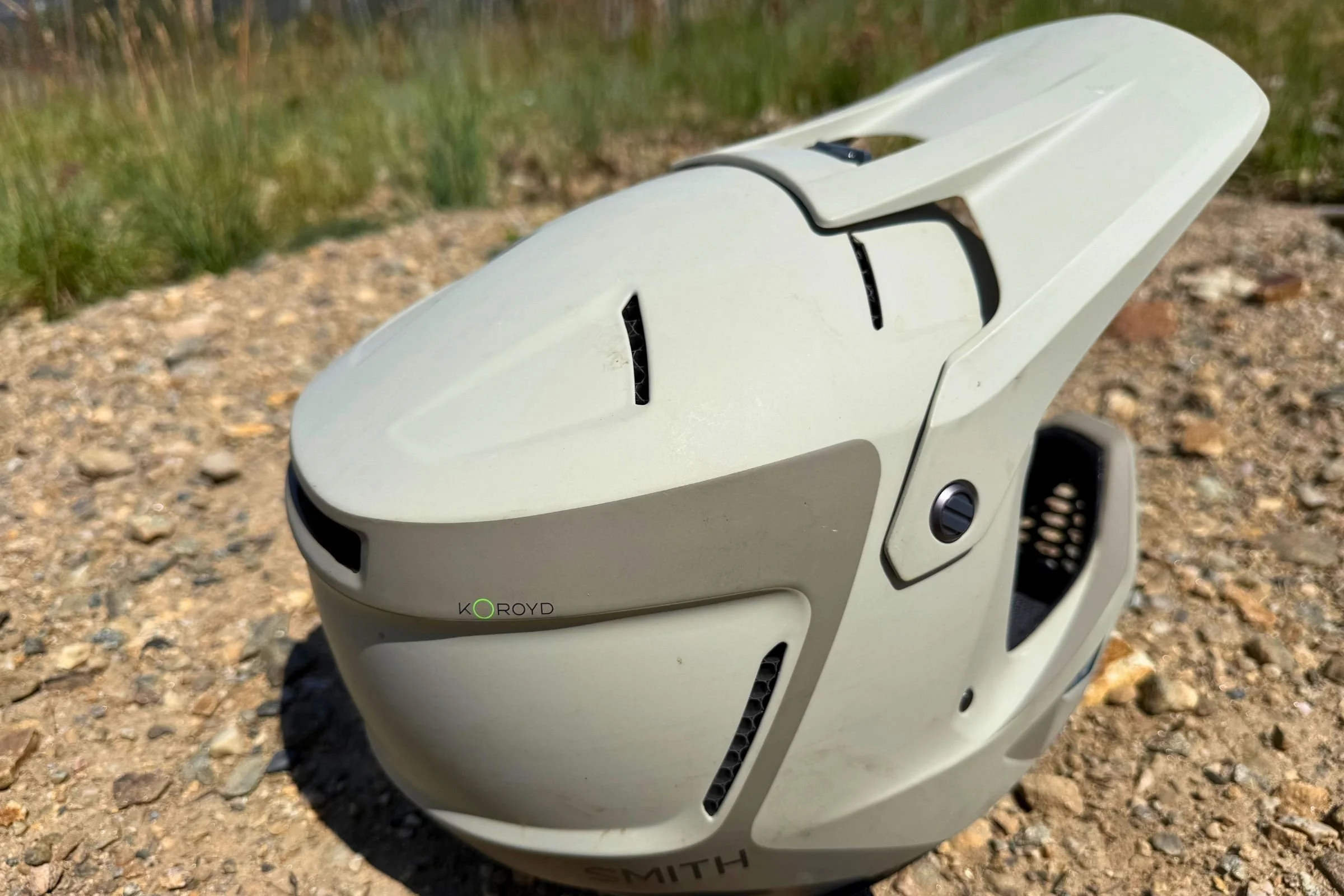 A Smith Hardline helmet resting on a rock, highlighting its ventilation design.