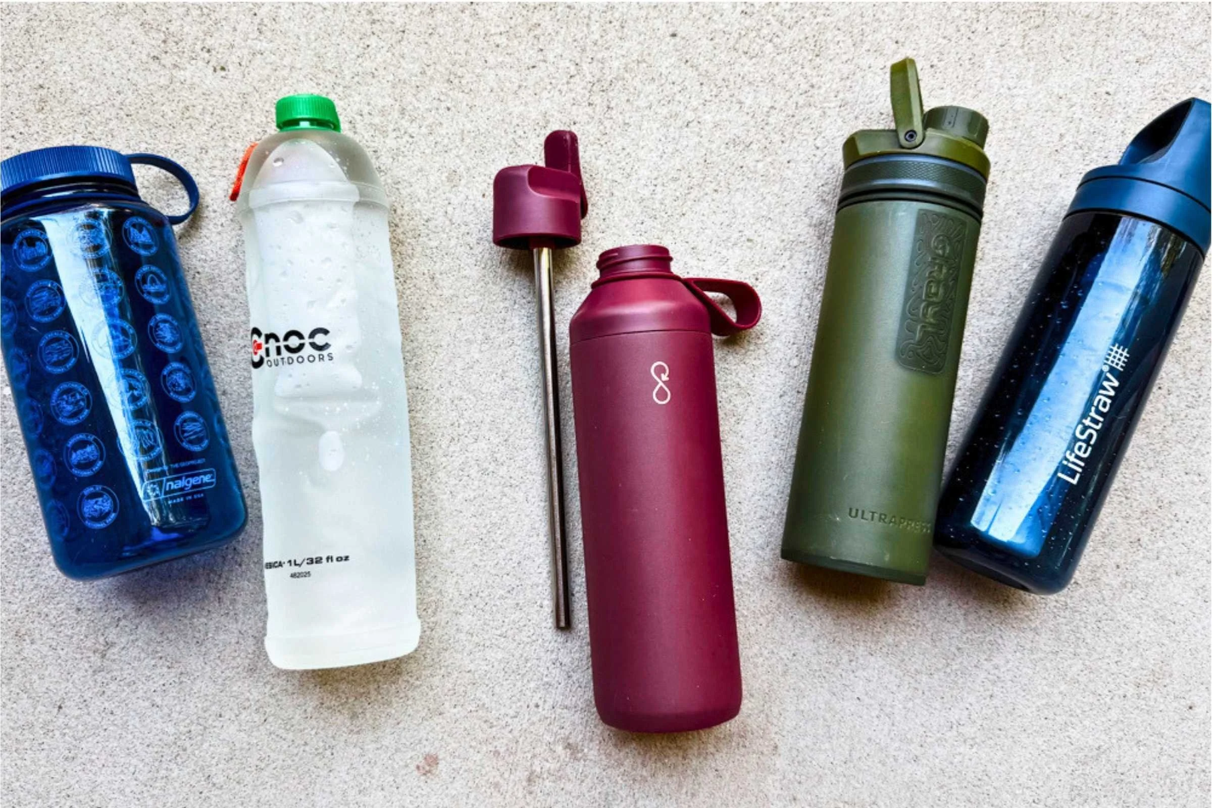 Five travel water bottles representing different types: rigid plastic, stainless steel, collapsible silicone, soft flask, and filter bottle.