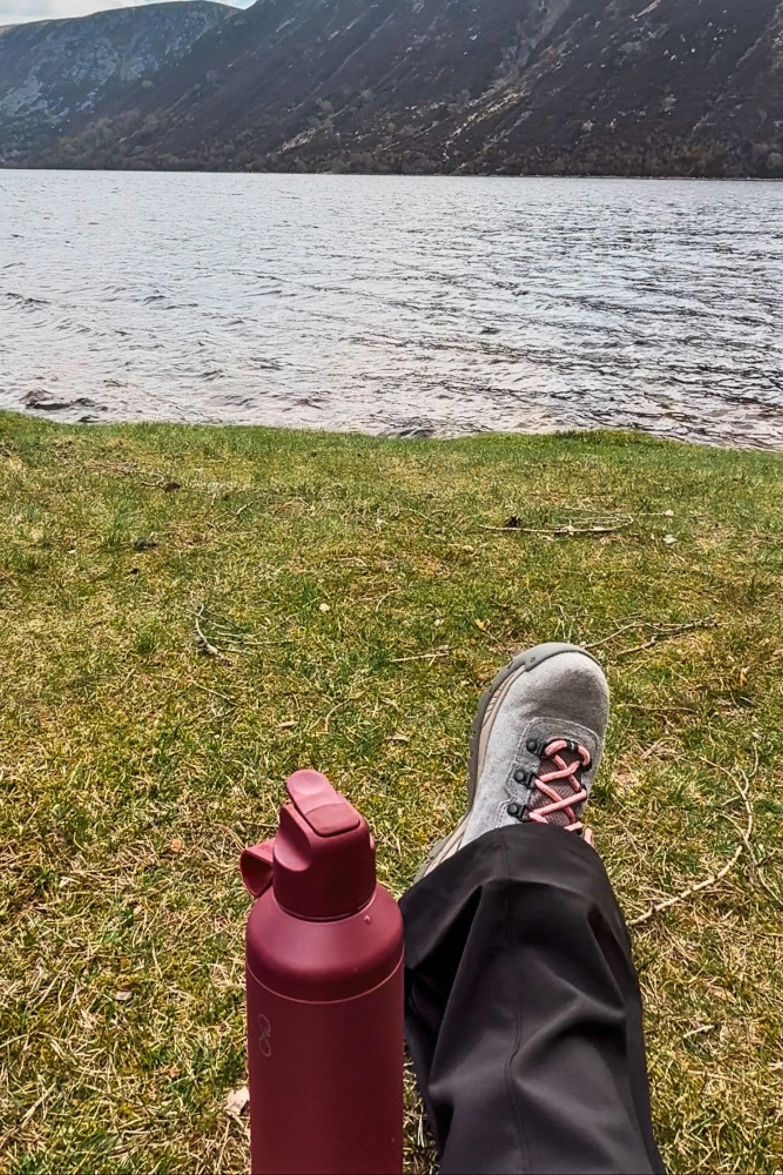 Ocean Bottle Peak Go displayed on grass against a mountain landscape in Scotland.
