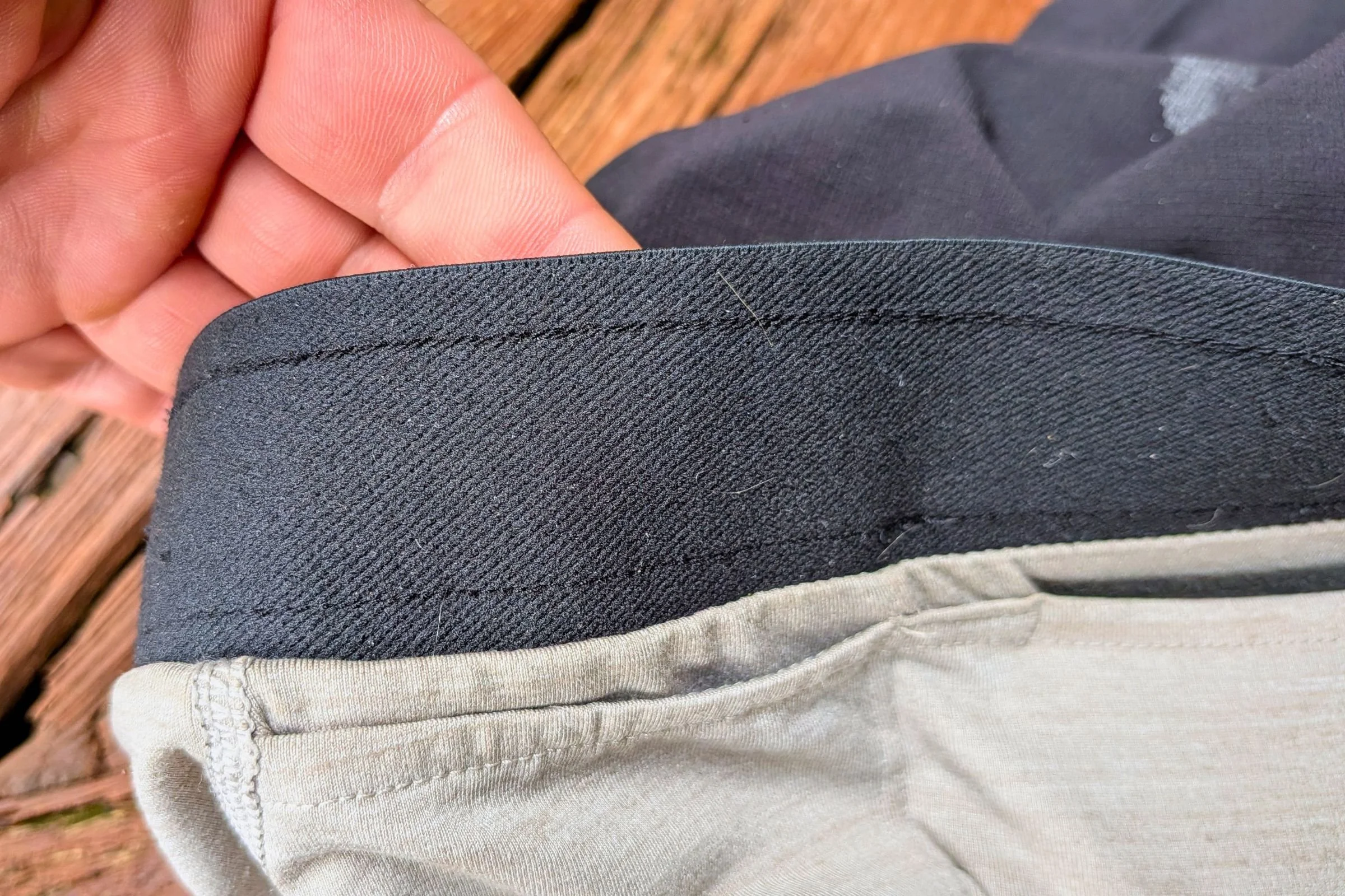 Close-up of a hand holding the pocket of Tracksmith Twilight Running Shorts.