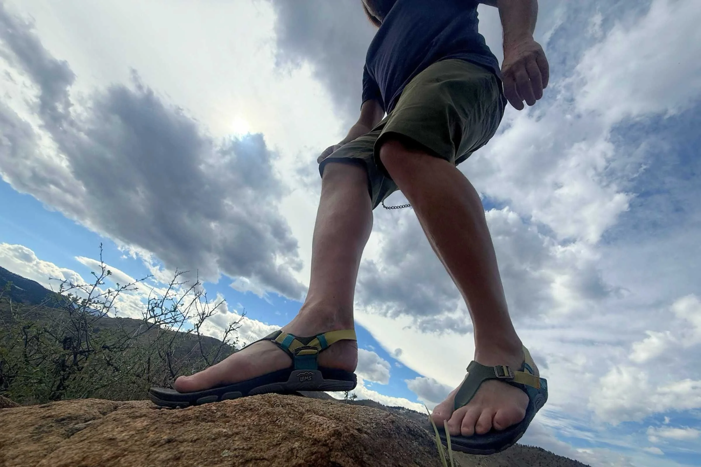 Tester out on a rocky trail in the Lems Switchback Sandal Knit