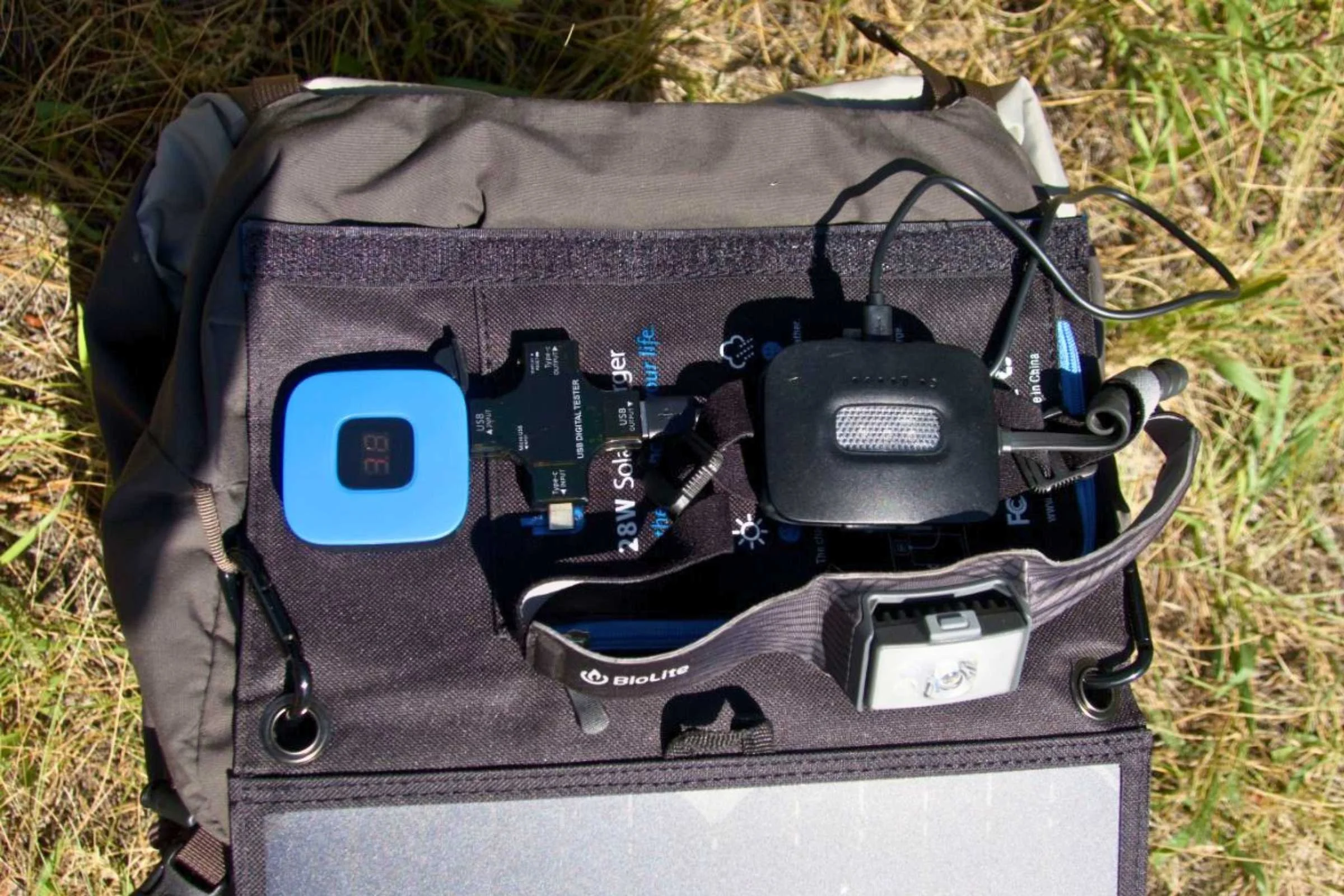 The Big Blue solar panel charging a headlamp in a field
