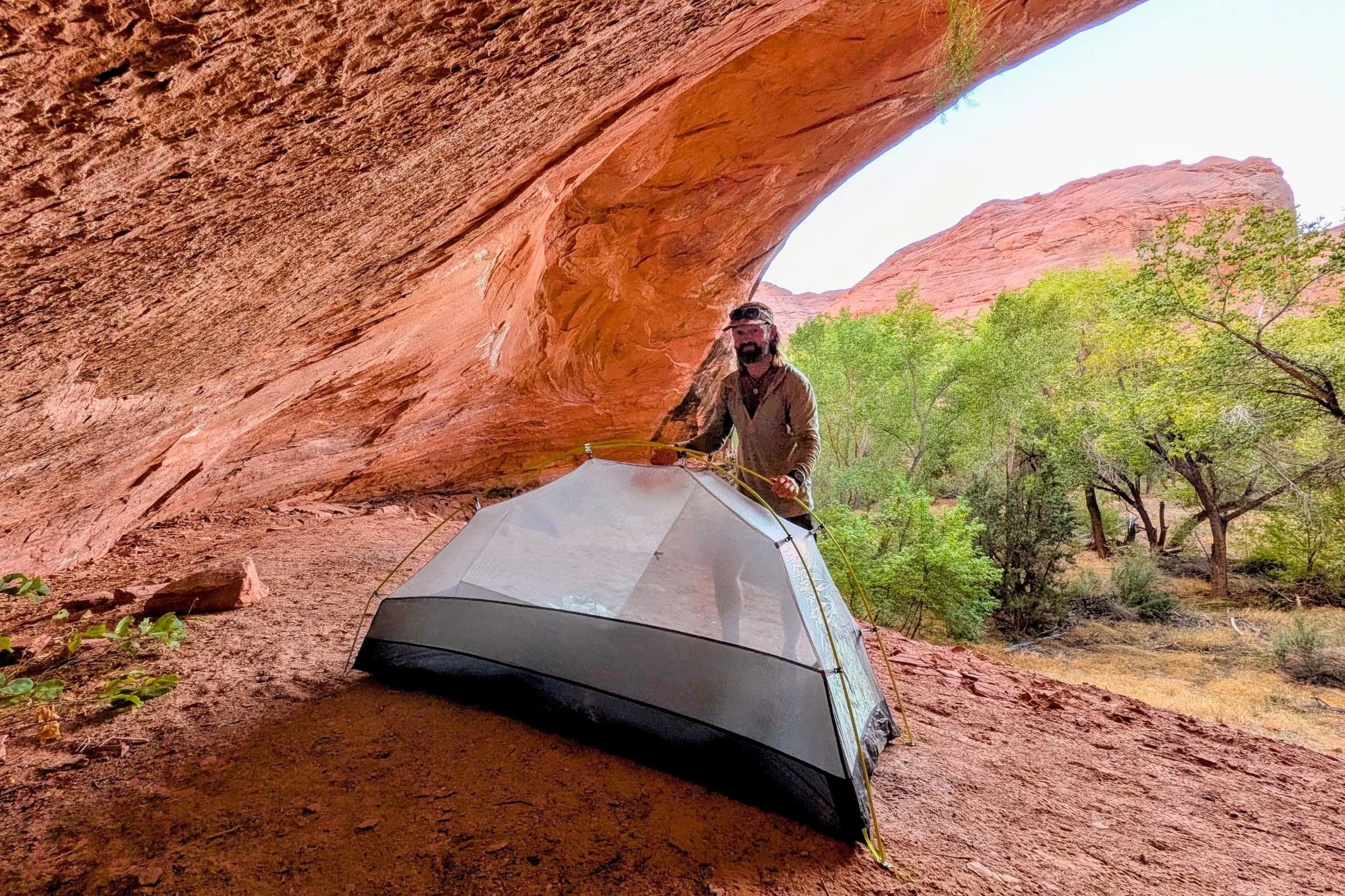 The author stands beside the Gossamer Gear The Free pitched beneath a sandstone overhang.