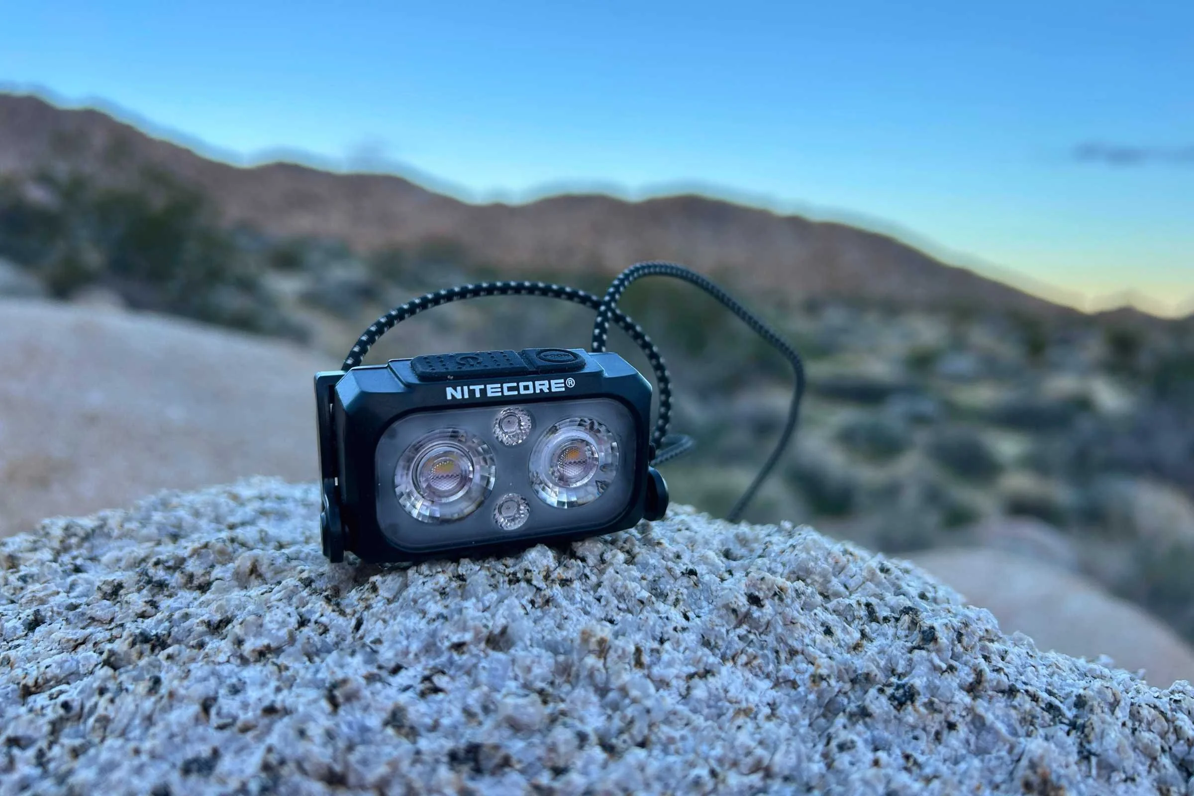 Nitecore NU25 MCT headlamp displayed on a rock