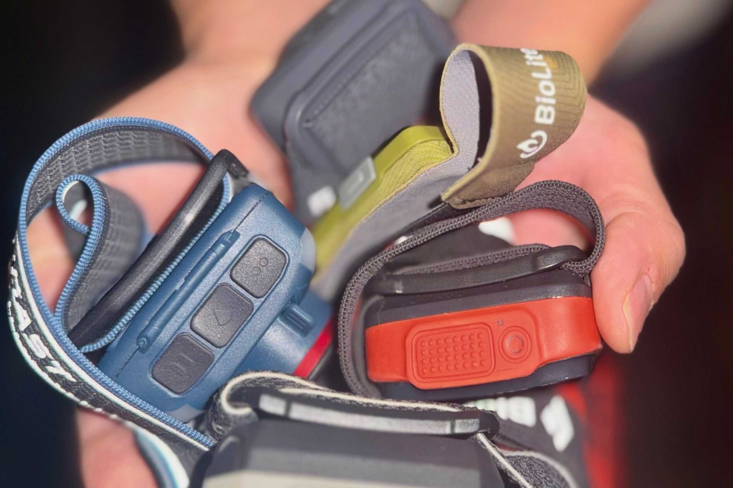 An assortment of headlamps. The COAST FL97R sticks out with its three distinct operation buttons.