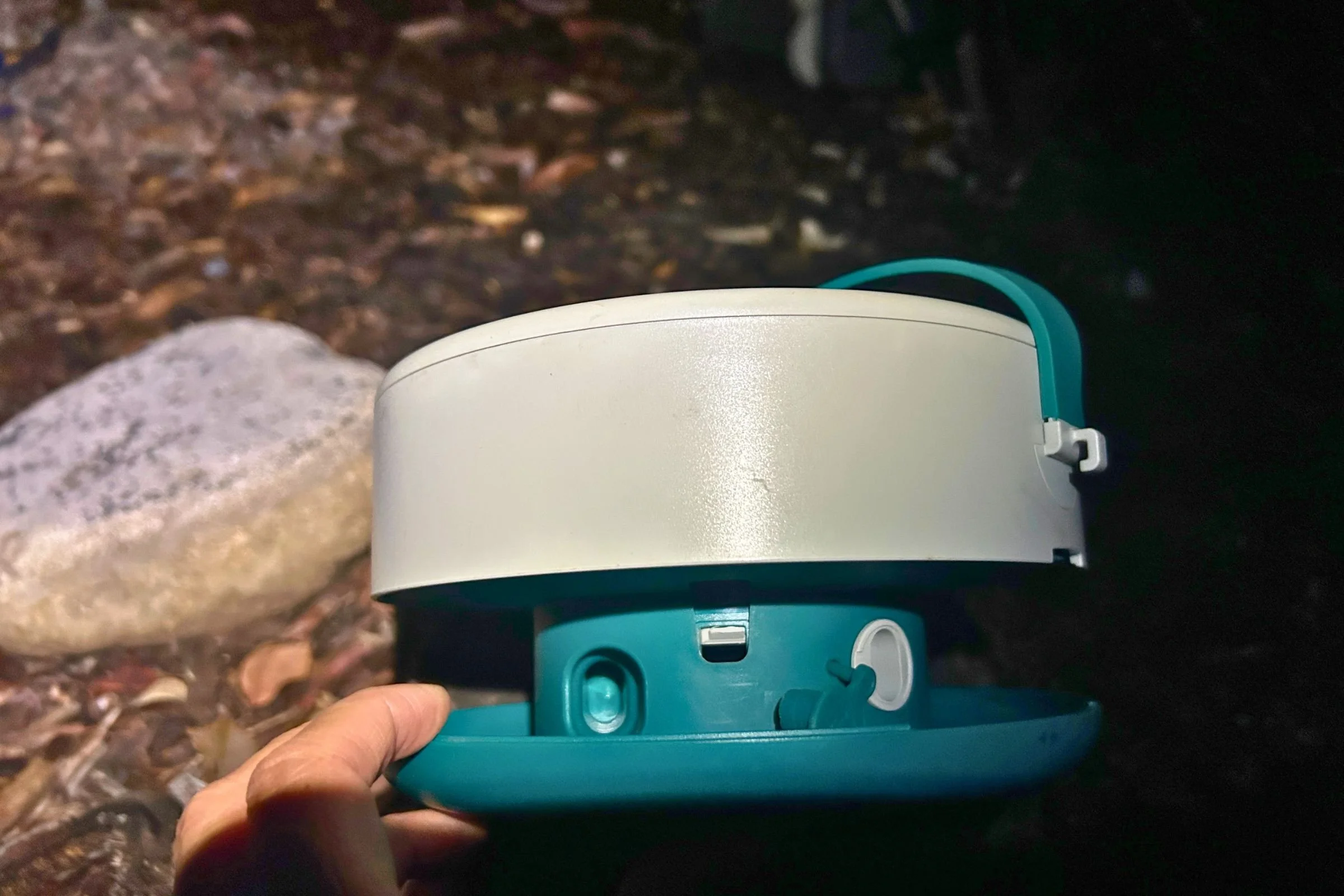 The BioLite Luci 44' Solar String Lights hub has a storage slot for the string’s plug on the left and a covered USB power port on the right, shown with its flap open.