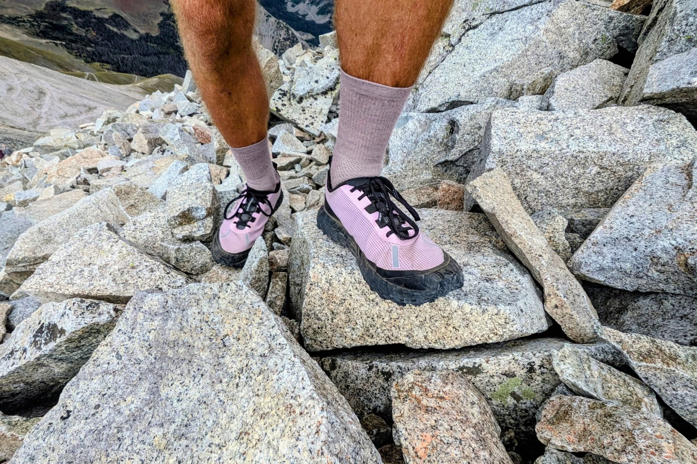 Man climbing a rocky mountain in Norda 000 Trail Running Shoes.