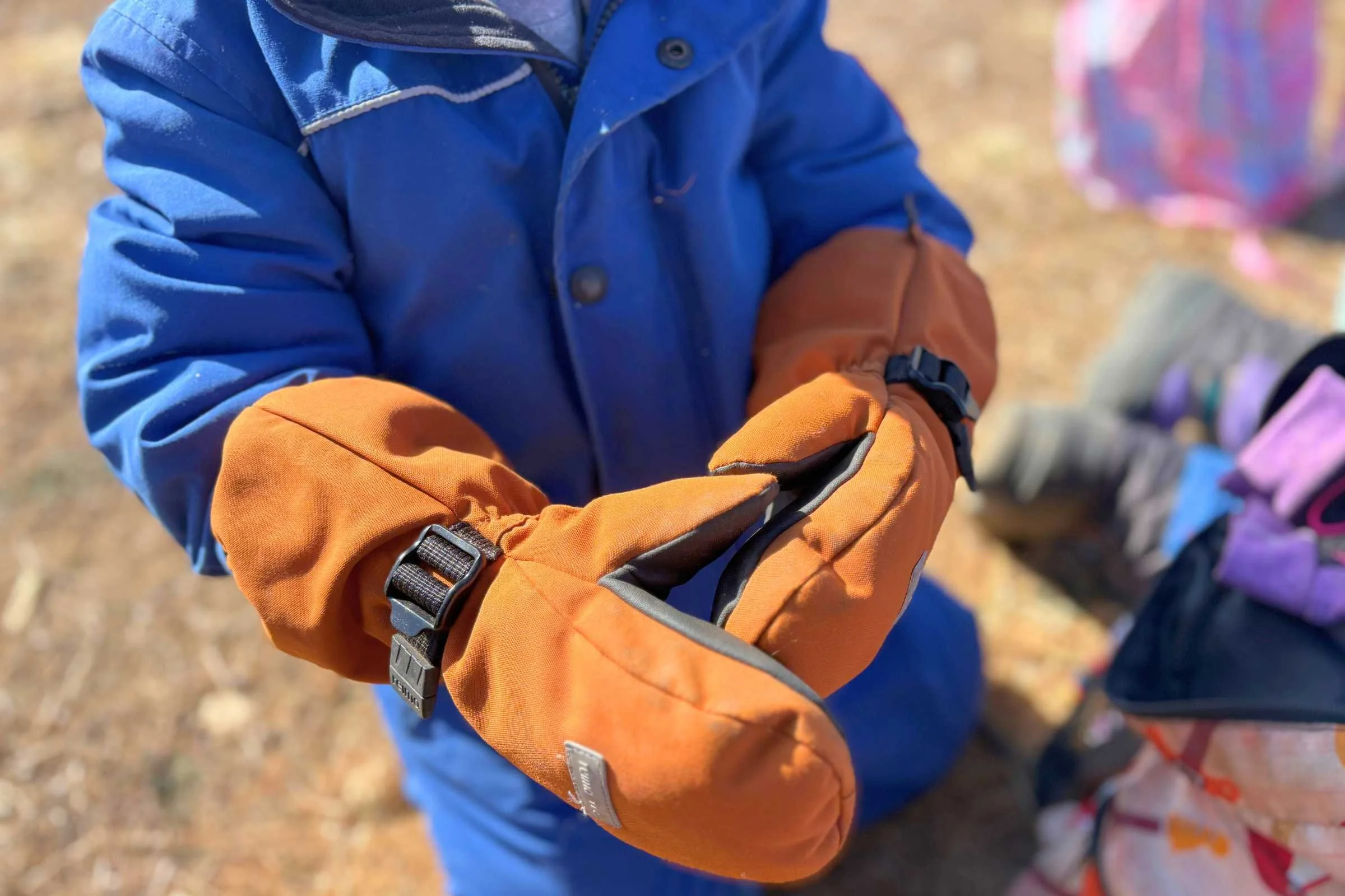 Child wearing Reima Ote winter gloves playing outside