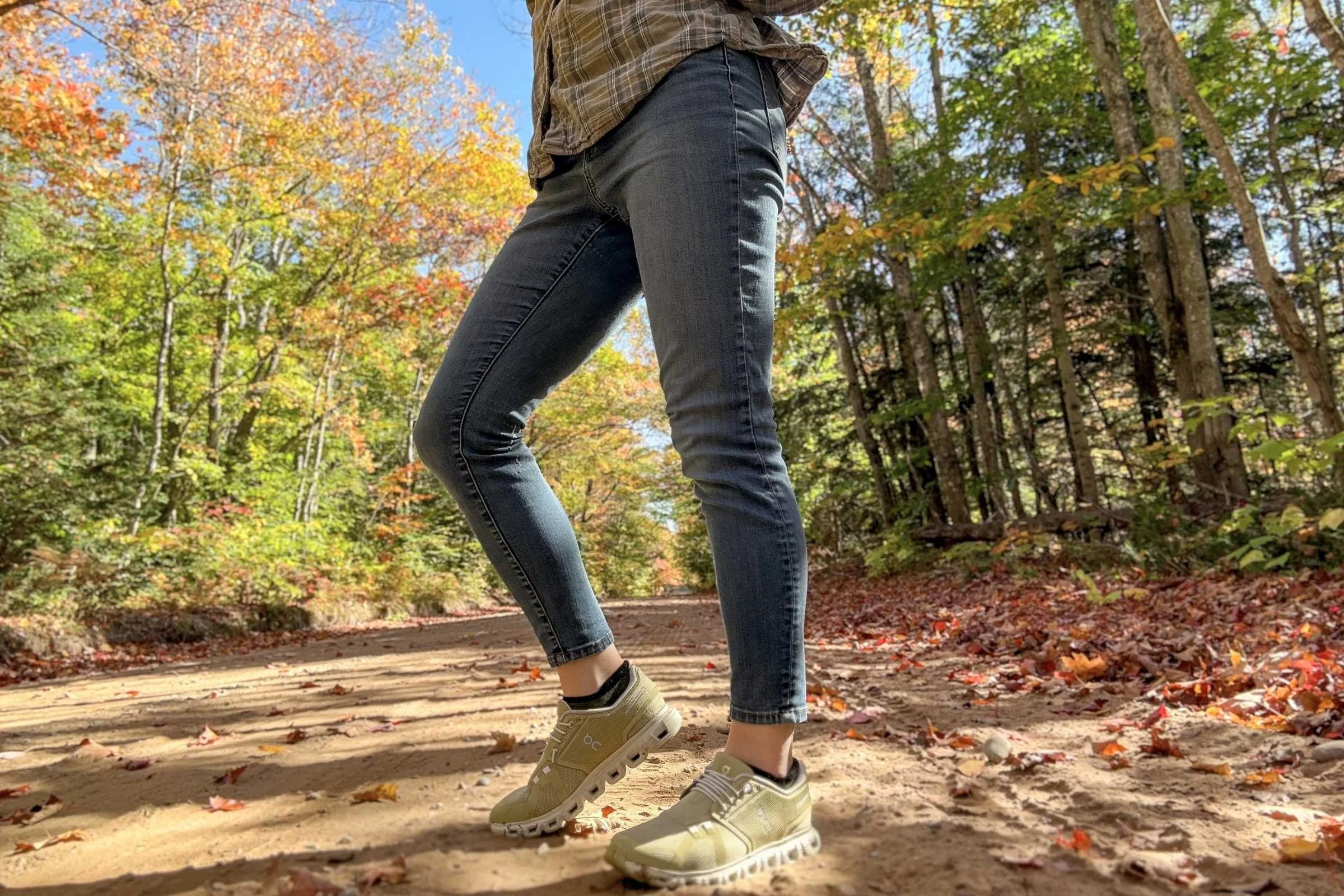 woman walks on dirt road wearing green on cloud 6 shoes
