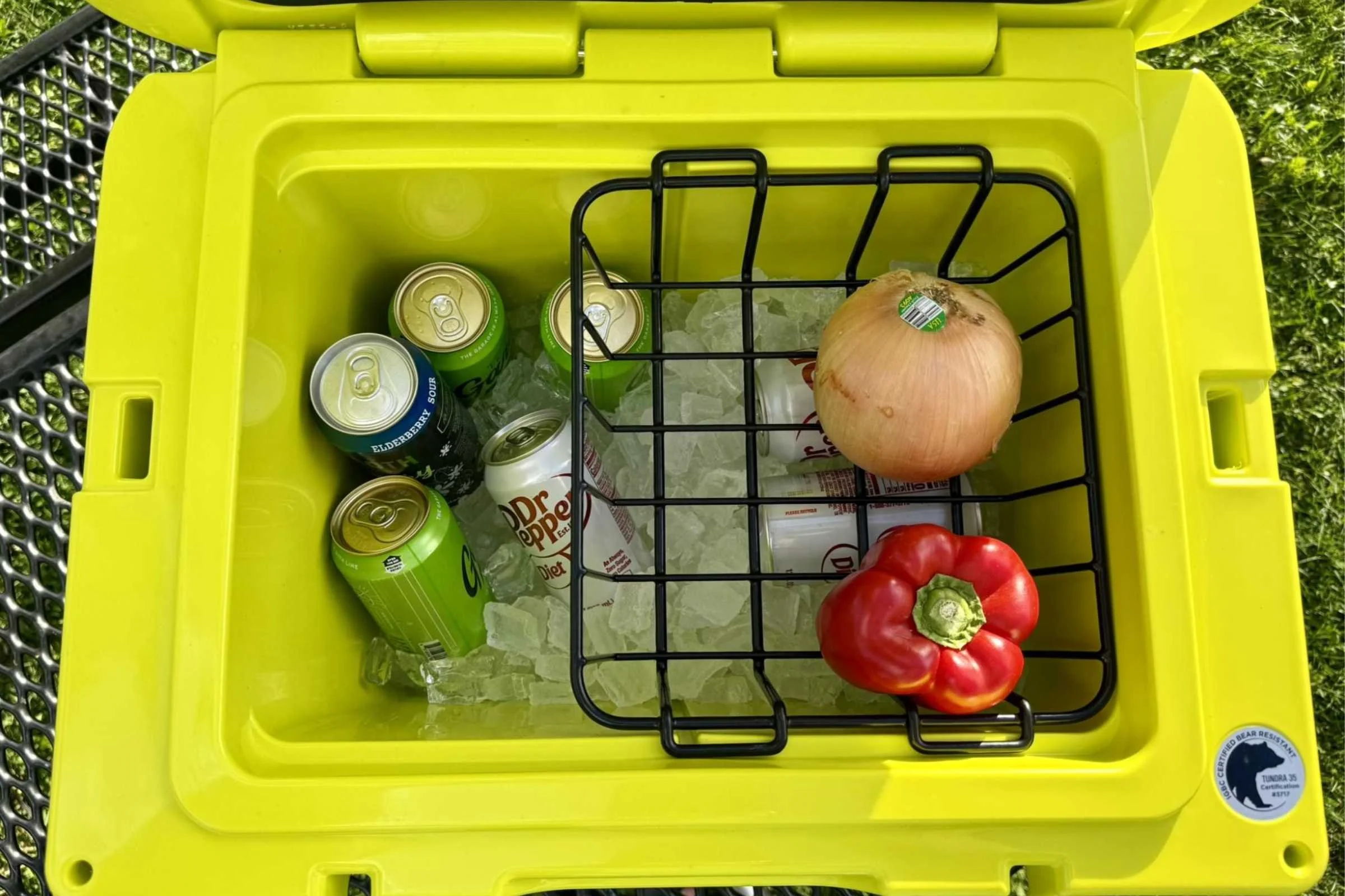 Interior organization with ice, drinks, and dry goods basket. Hinge, tie down points, and lock slots are also shown.