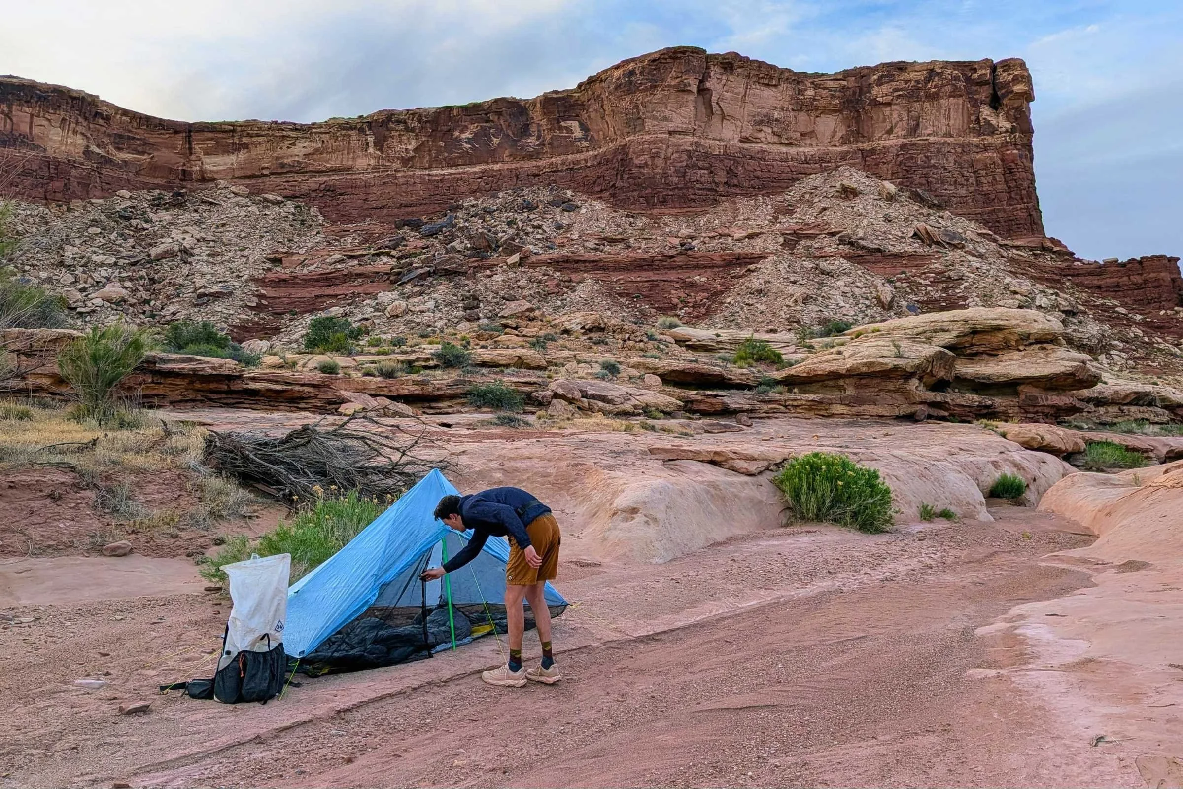 Man actively setting up a Zpacks Hexamid Ultralight Tent in the desert.