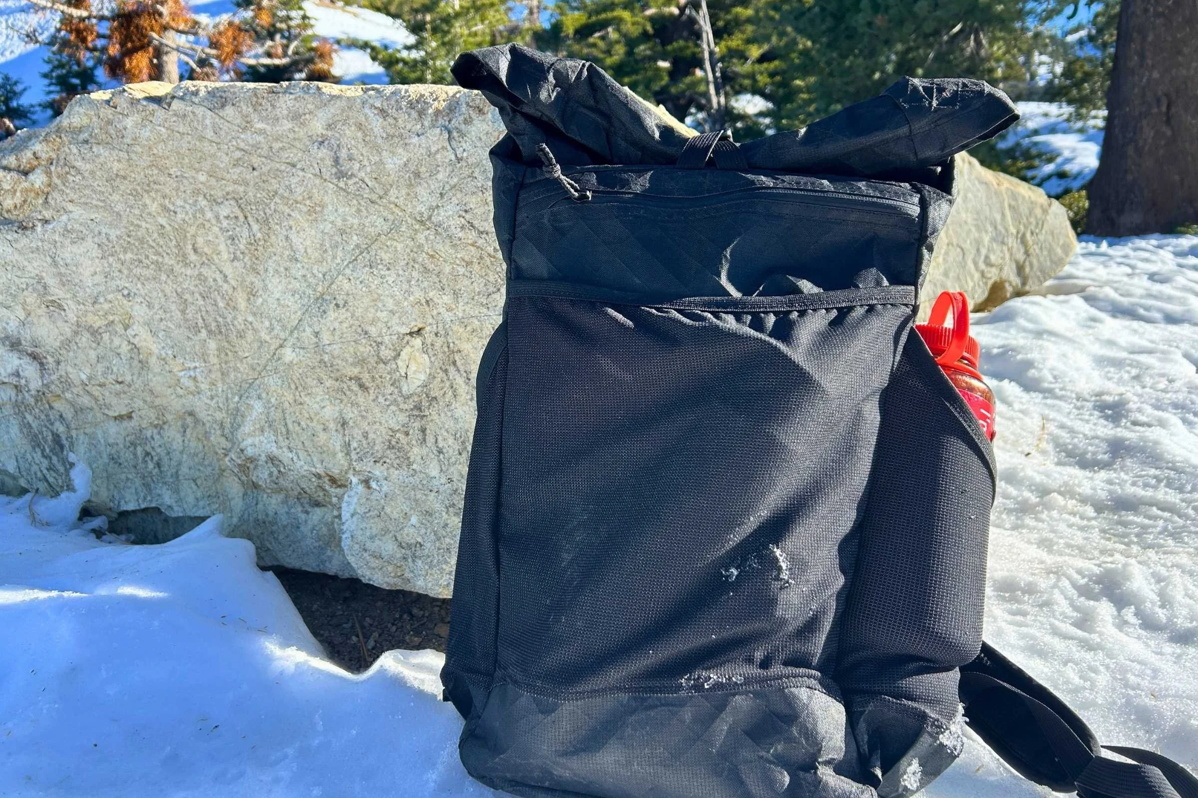the ula ultra node 20l backpack on the ground in the snow