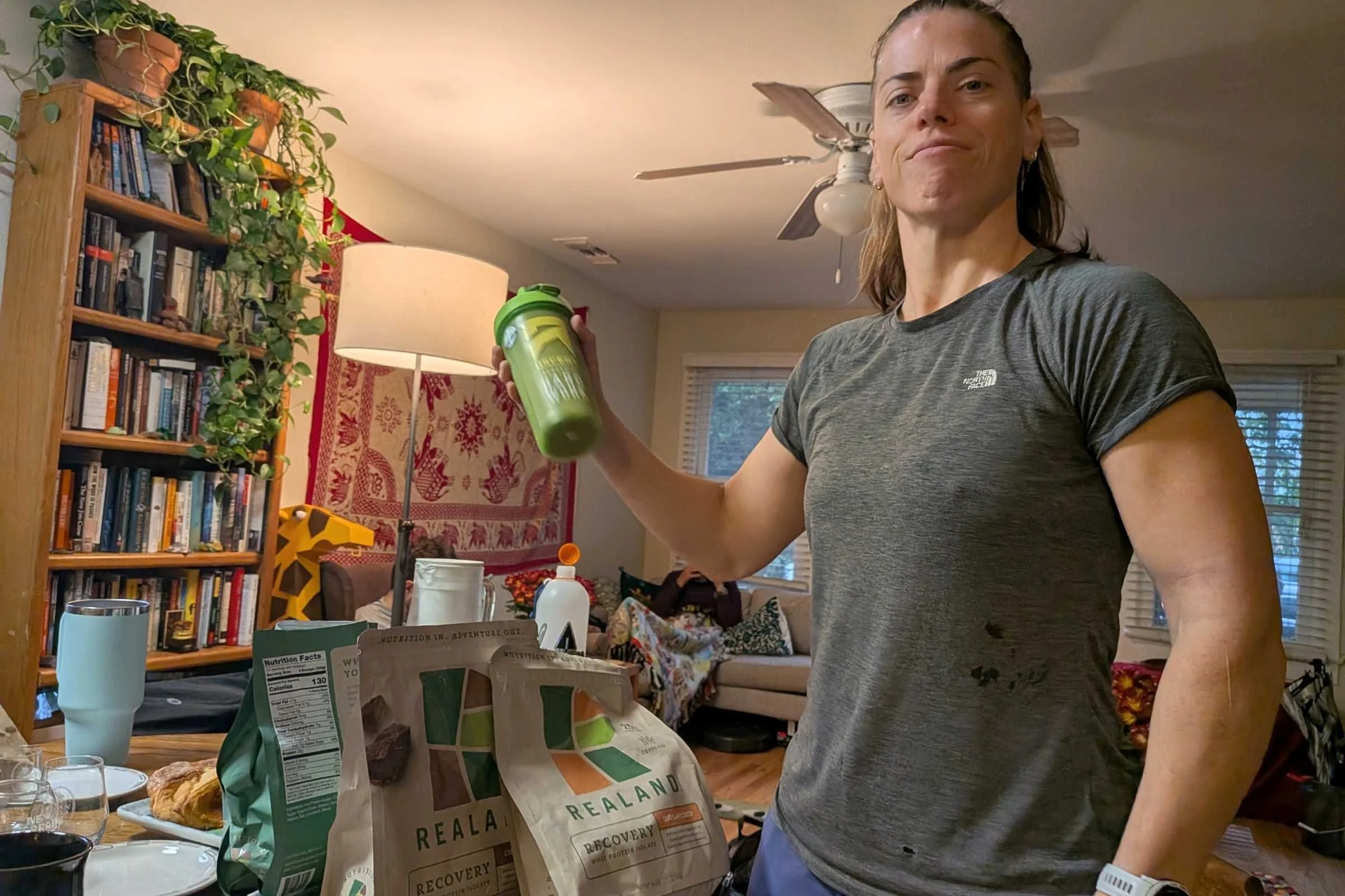 Woman inside shaking a shaker bottle of protein