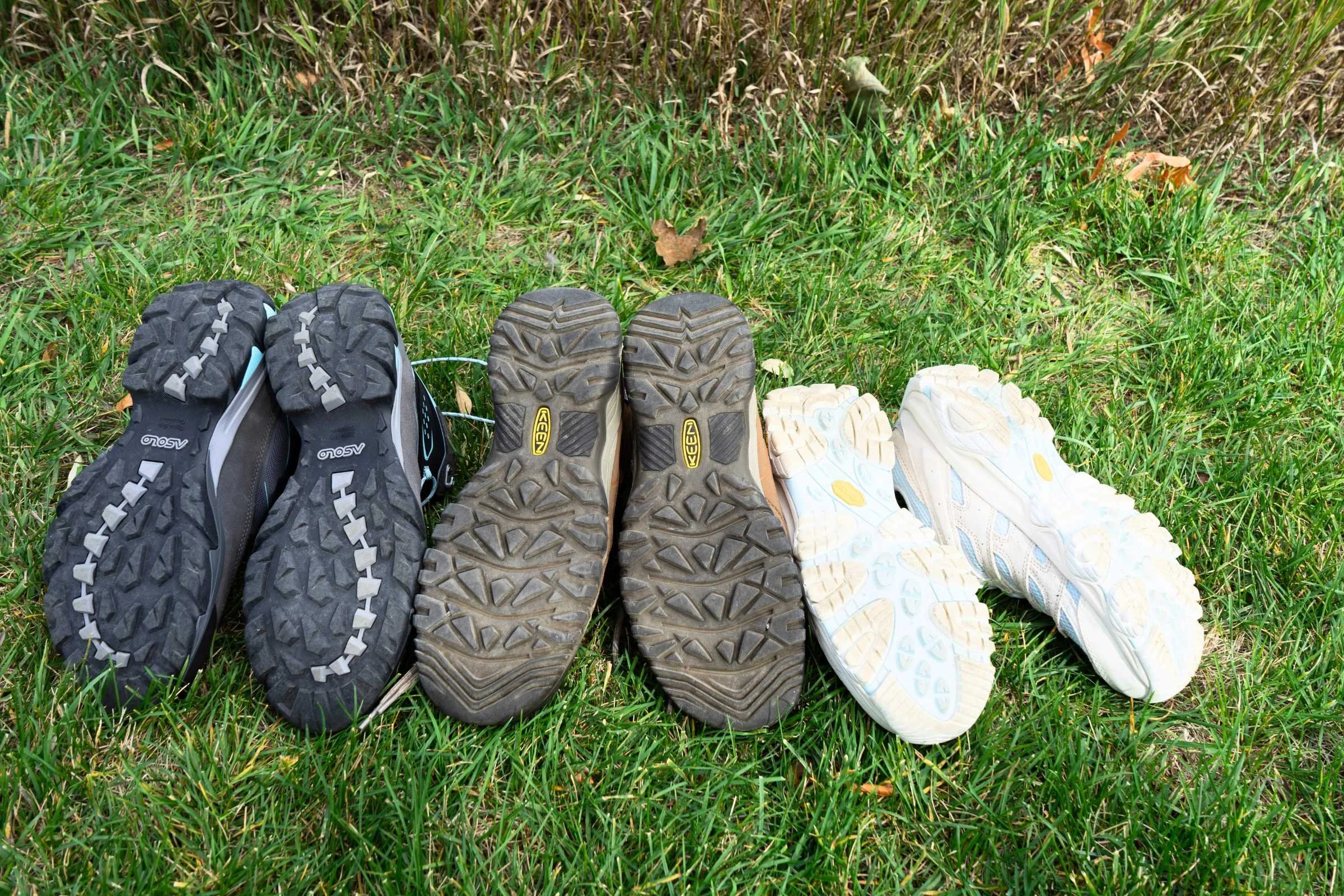 the outsoles of three pairs of hiking boots