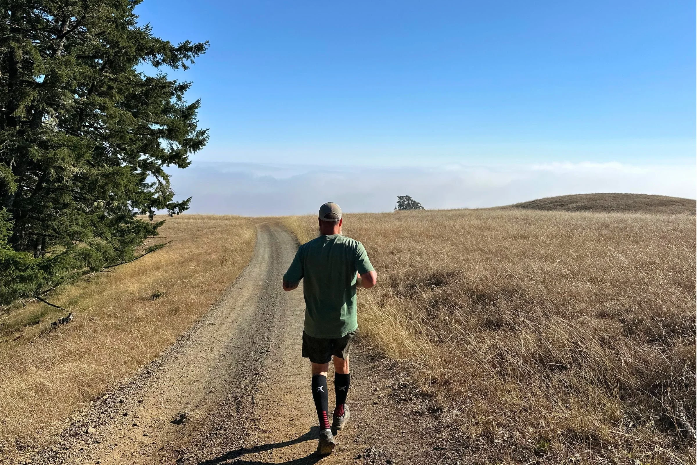 A tester running a dirt road in Rymora Compression Socks