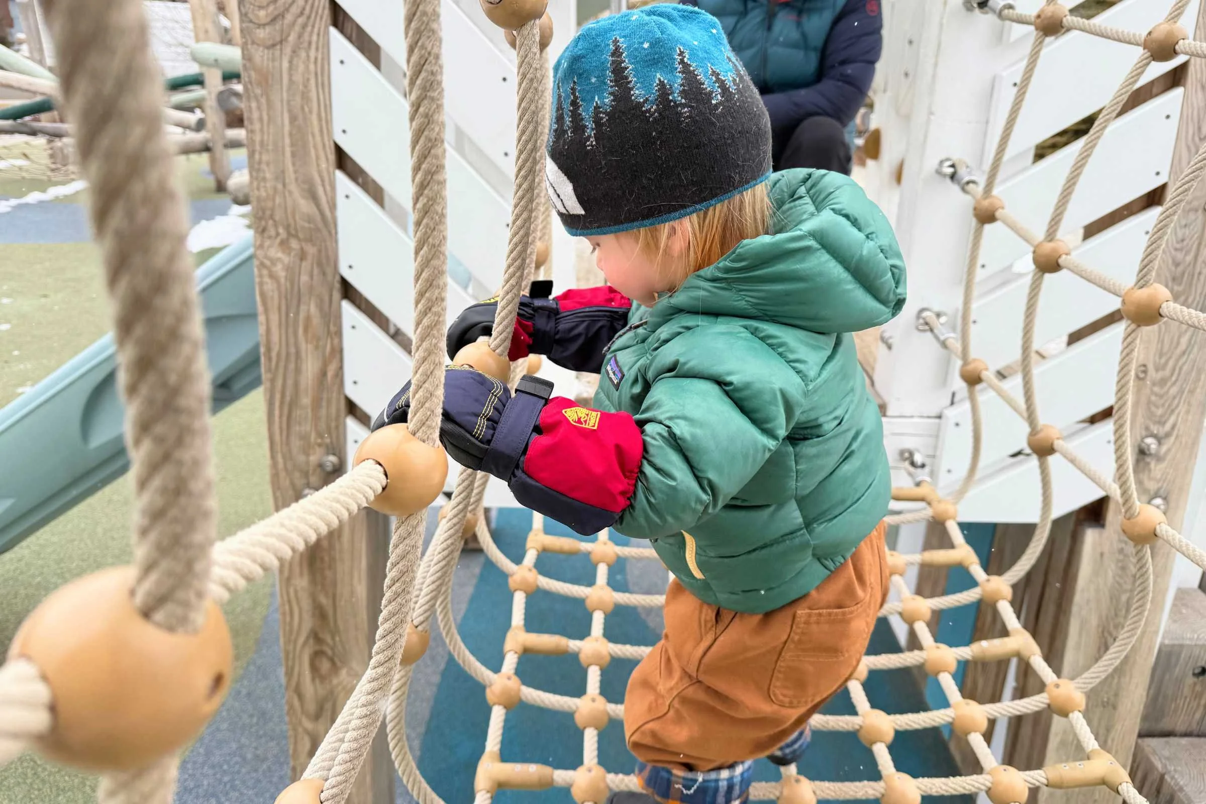 Toddler playing on playground wearing Hestra Baby Zip Long Mitts