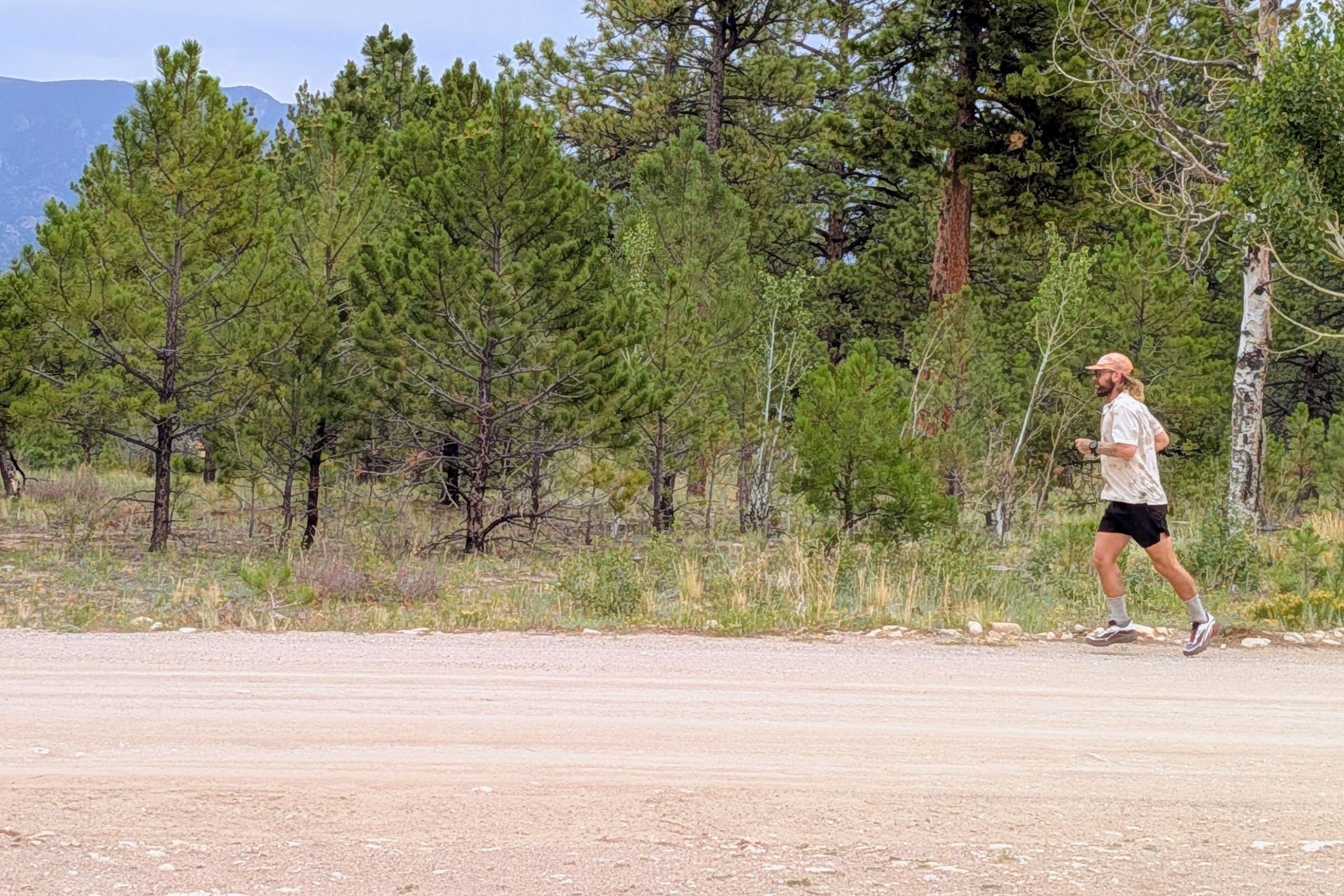 Man running on dirt road, wearing Salomon Genesis 2 shoes.