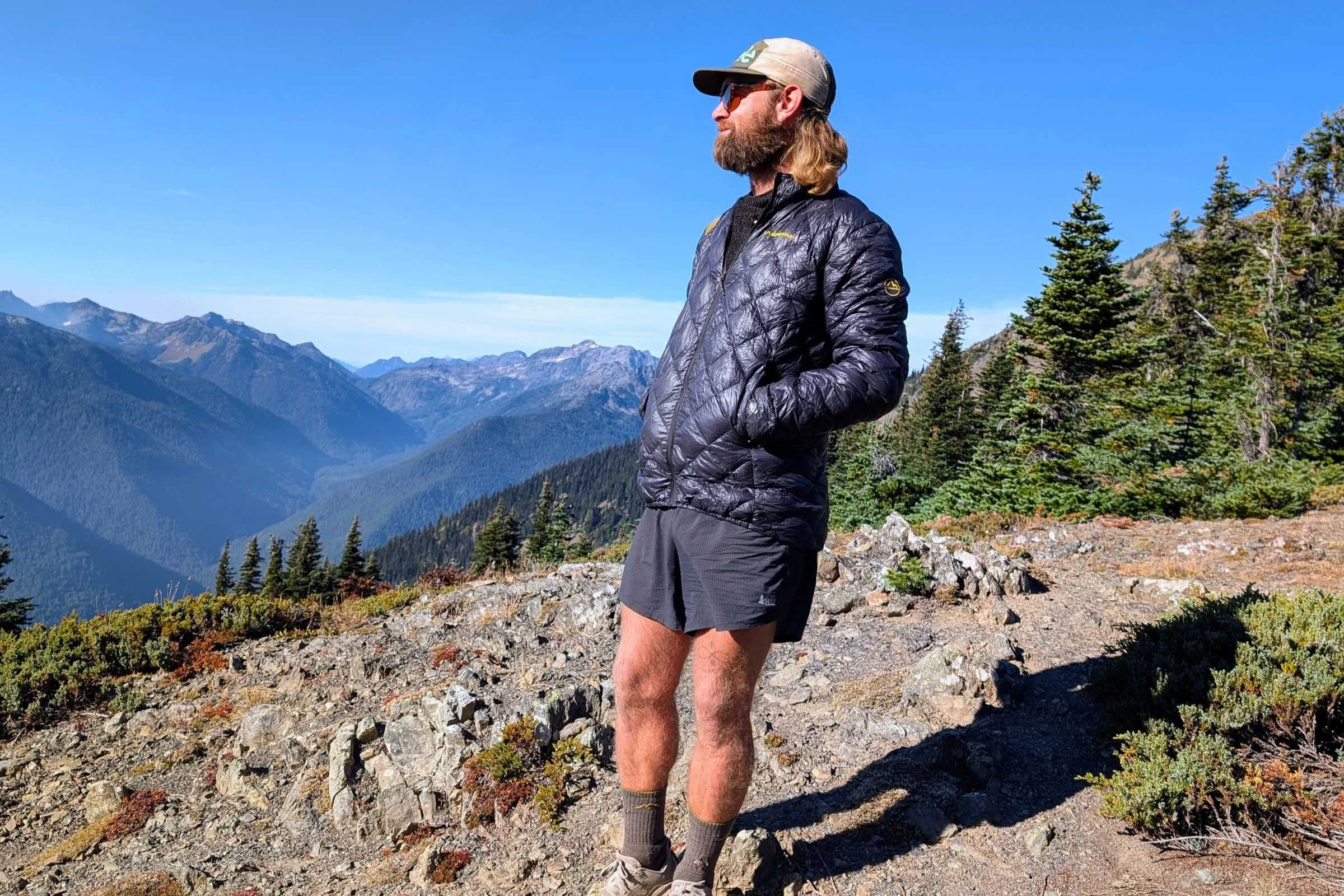 Man wearing the La Sportiva Down jacket looking out over the mountains