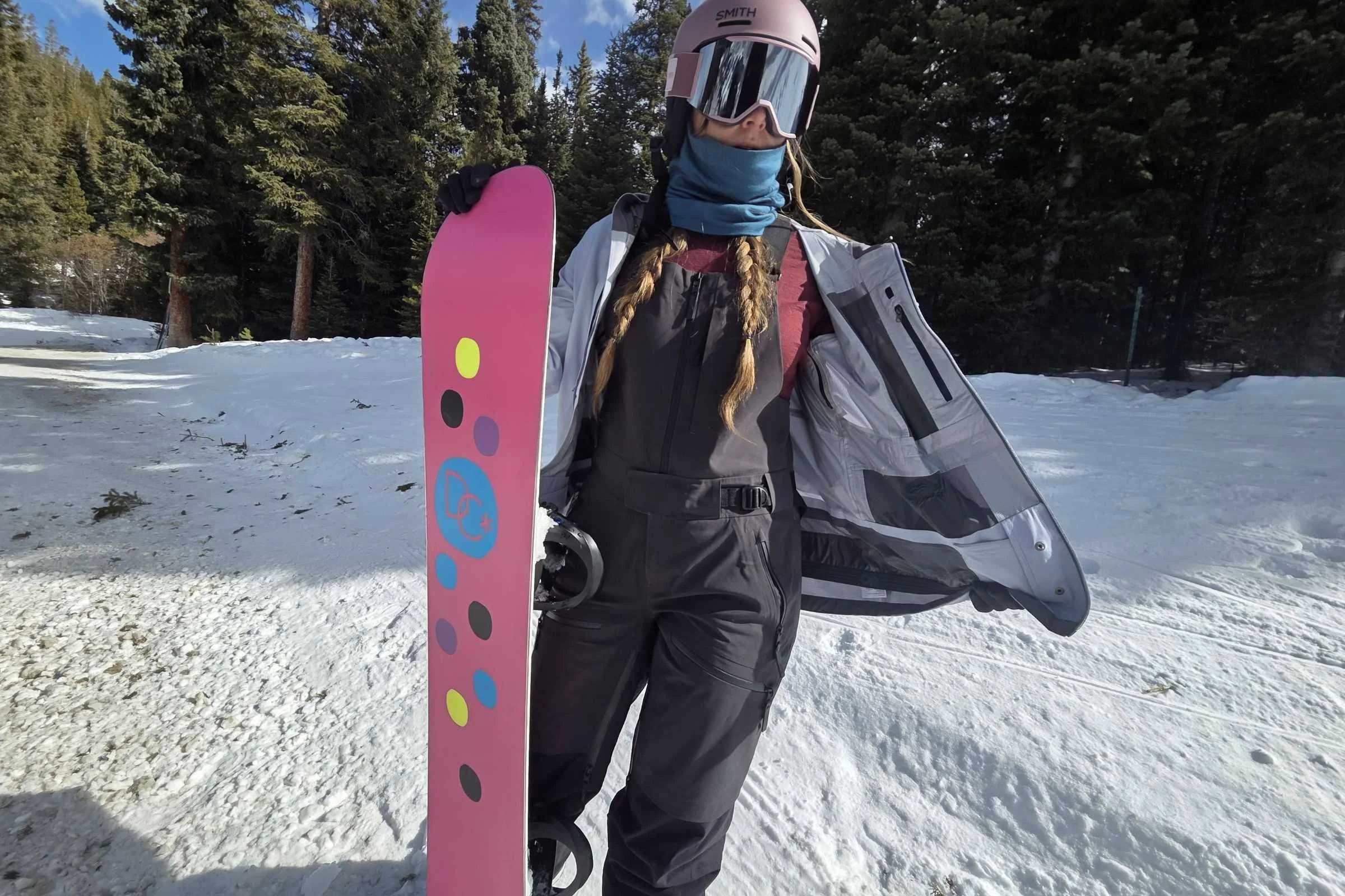 The author showing her base layer and bibs underneath her snowboarding jacket
