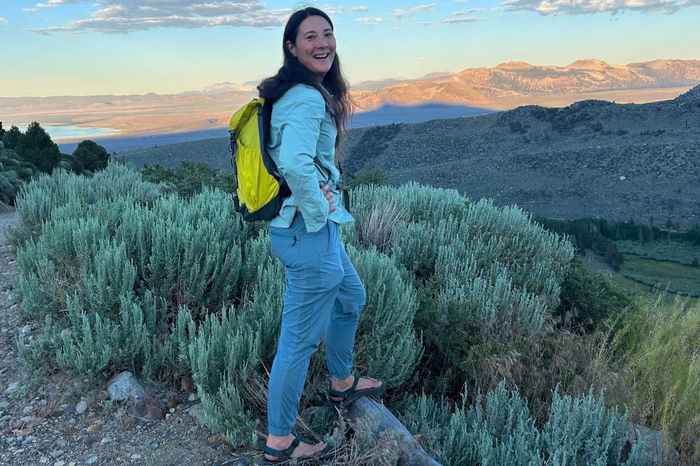 Liz Thomas wearing the yellow REI Flash 22 pack while hiking in the desert