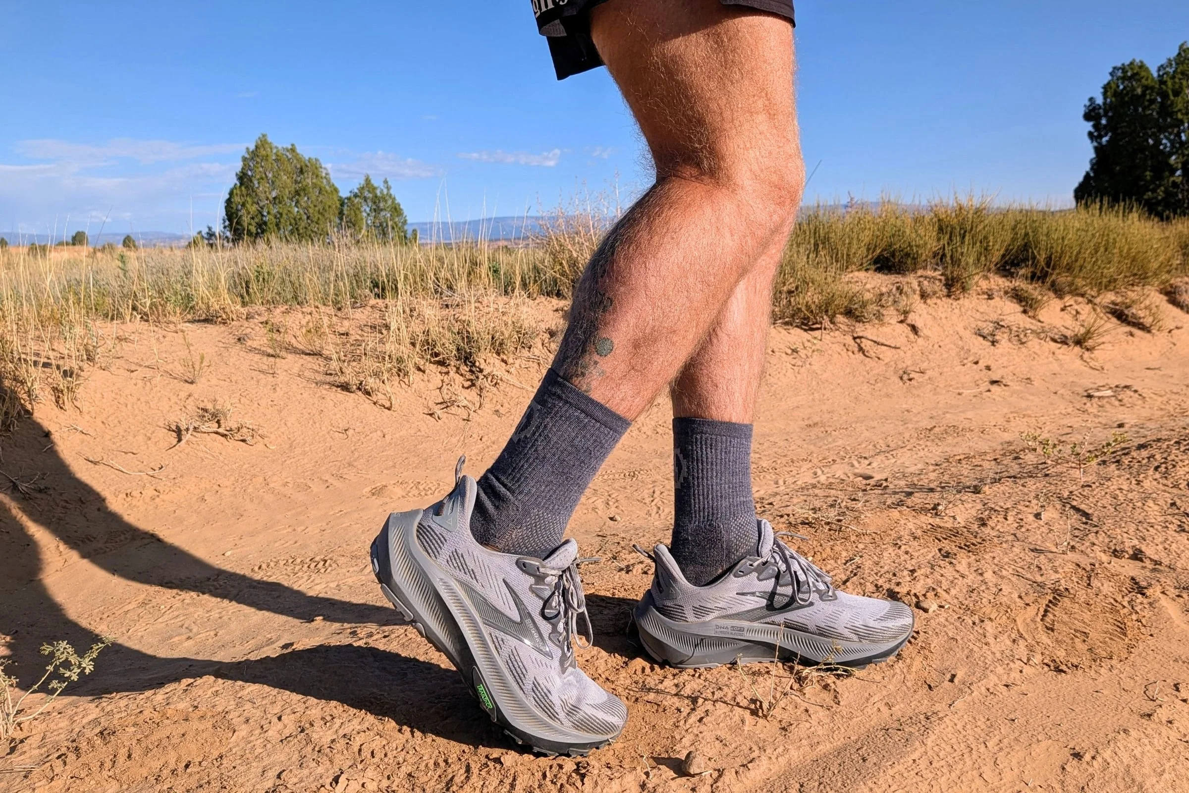 Man in Brooks Ghost trail running shoes standing on a dirt road.