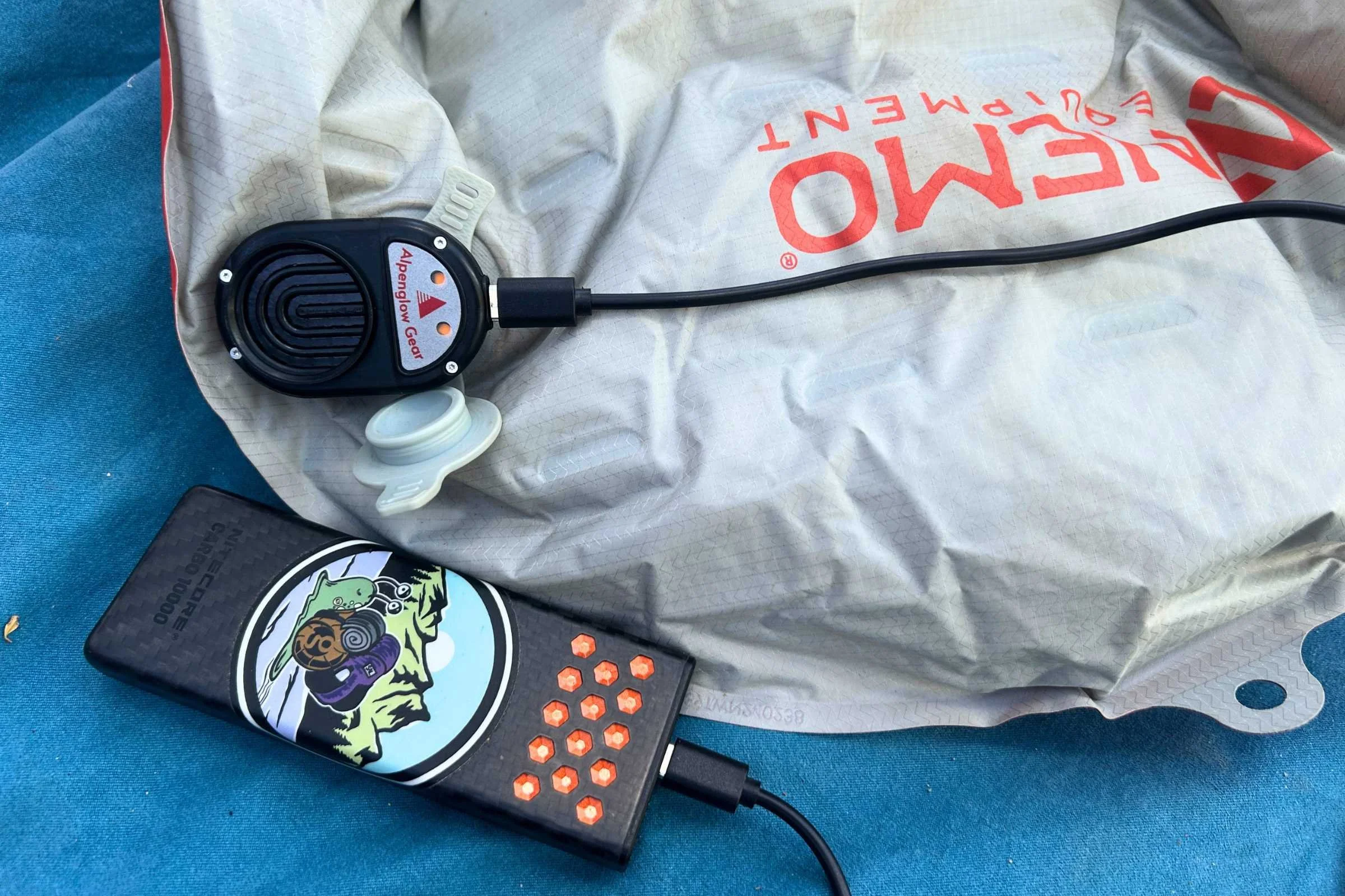 Alpenblow Lux setup with a cell phone and charger resting on top of a bag.