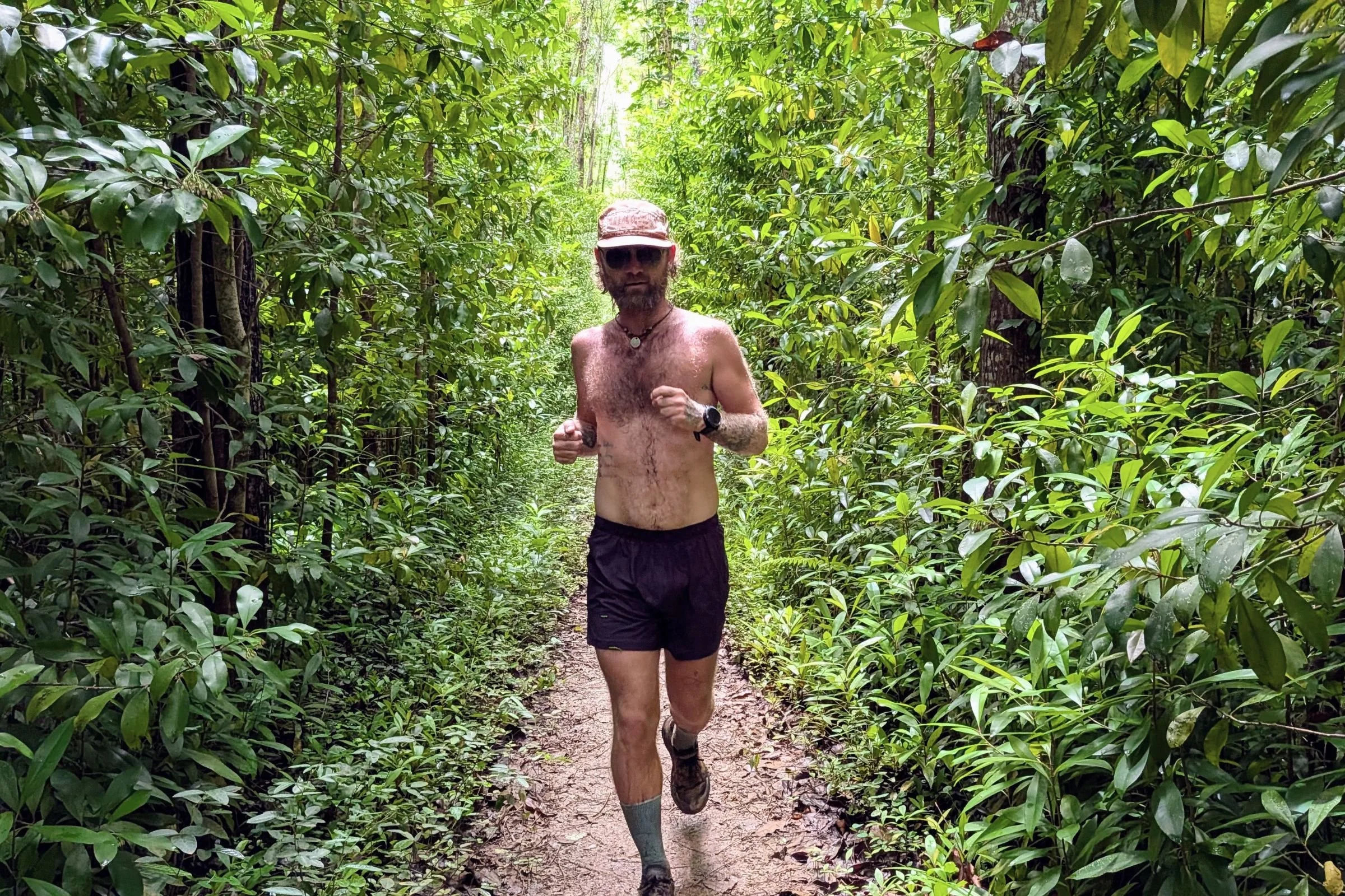 Tracksmith Twilight Running Shorts worn by a runner moving through a jungle path.