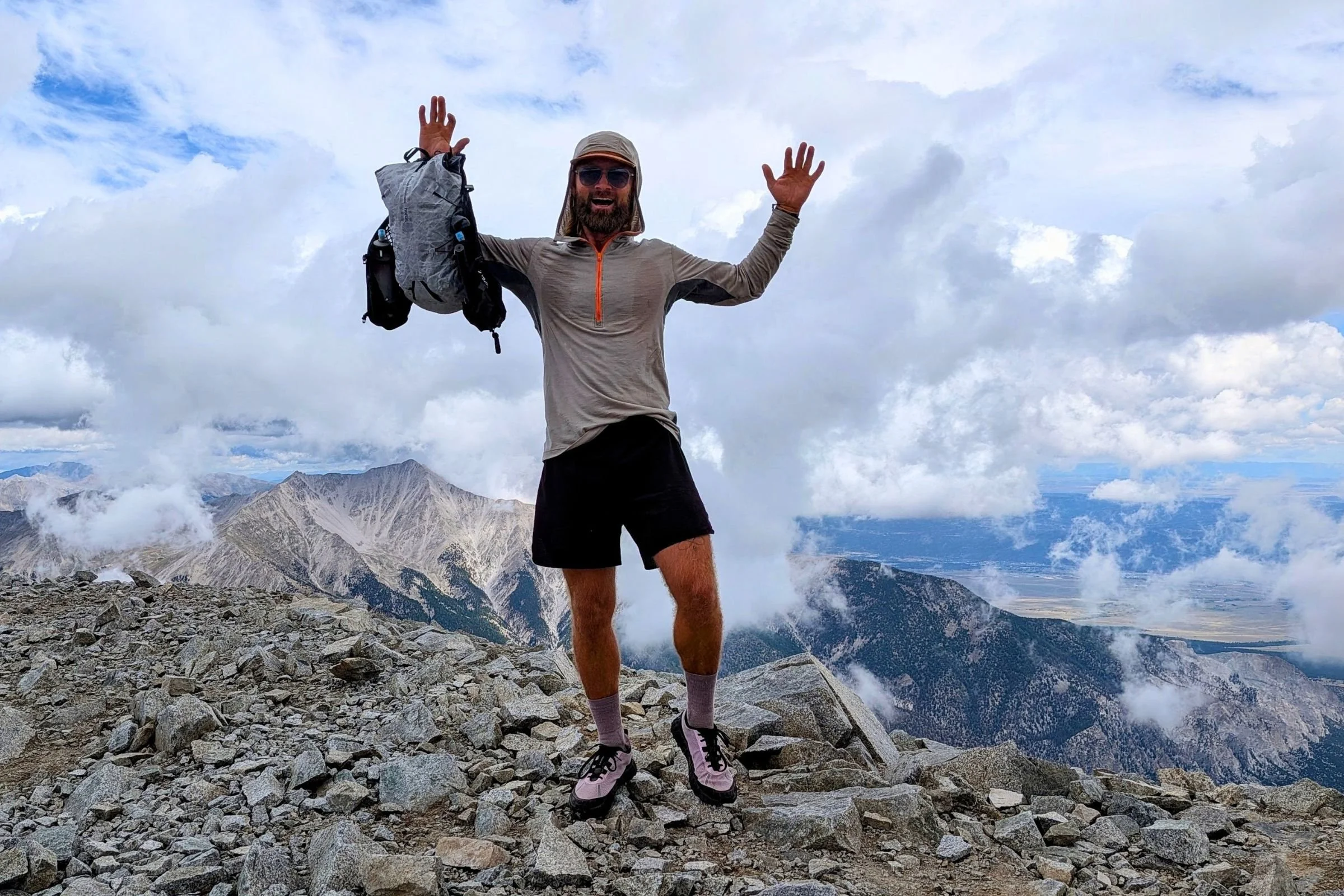 Sam Schild holds the Black Diamond Distance 15 Backpack on a rocky mountain summit