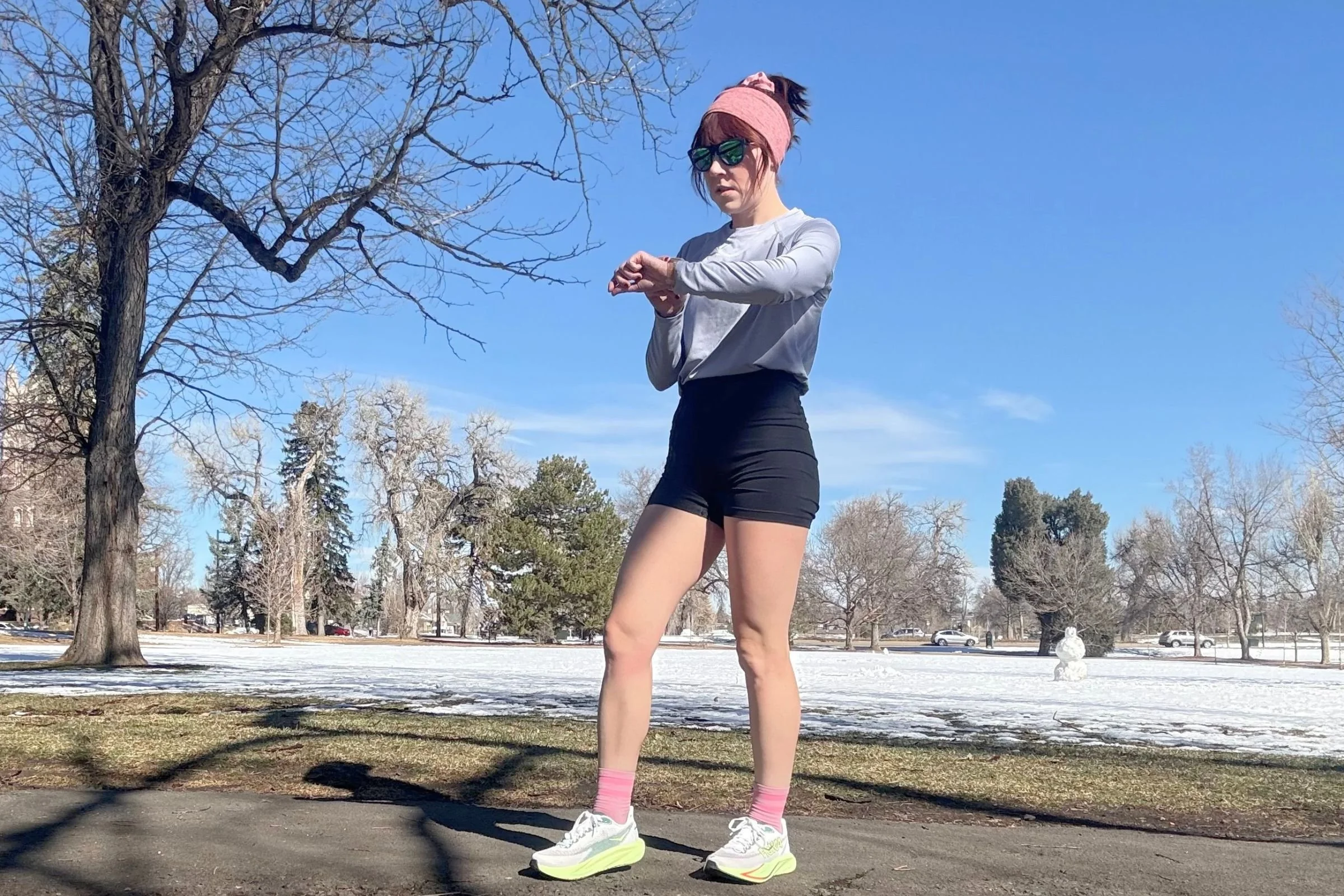 Tester out on a snowy run in the REI Swiftland Long Sleeve