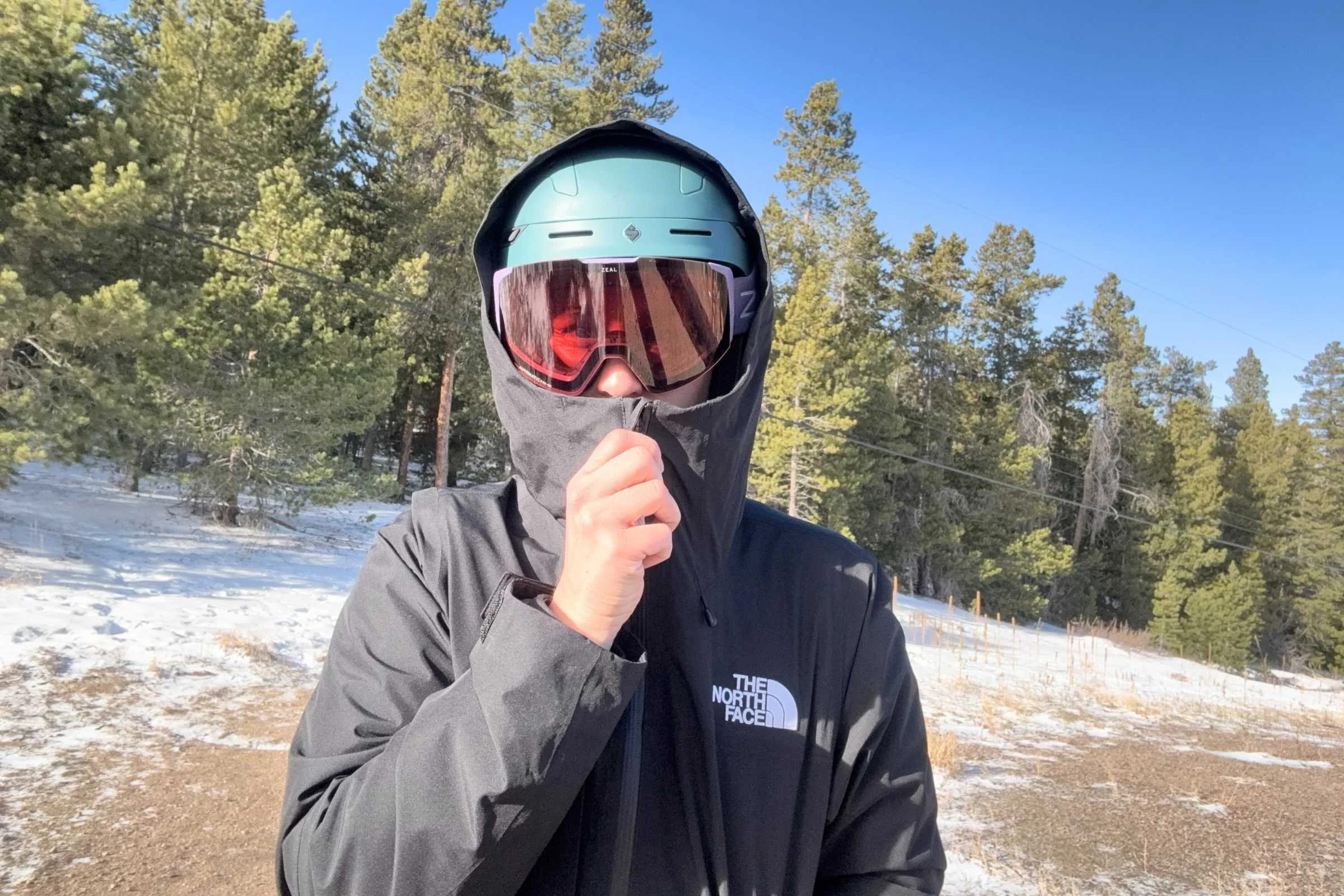 person wearing the north face thermoball snow triclimate jacket with the zipper zipped up to their goggles